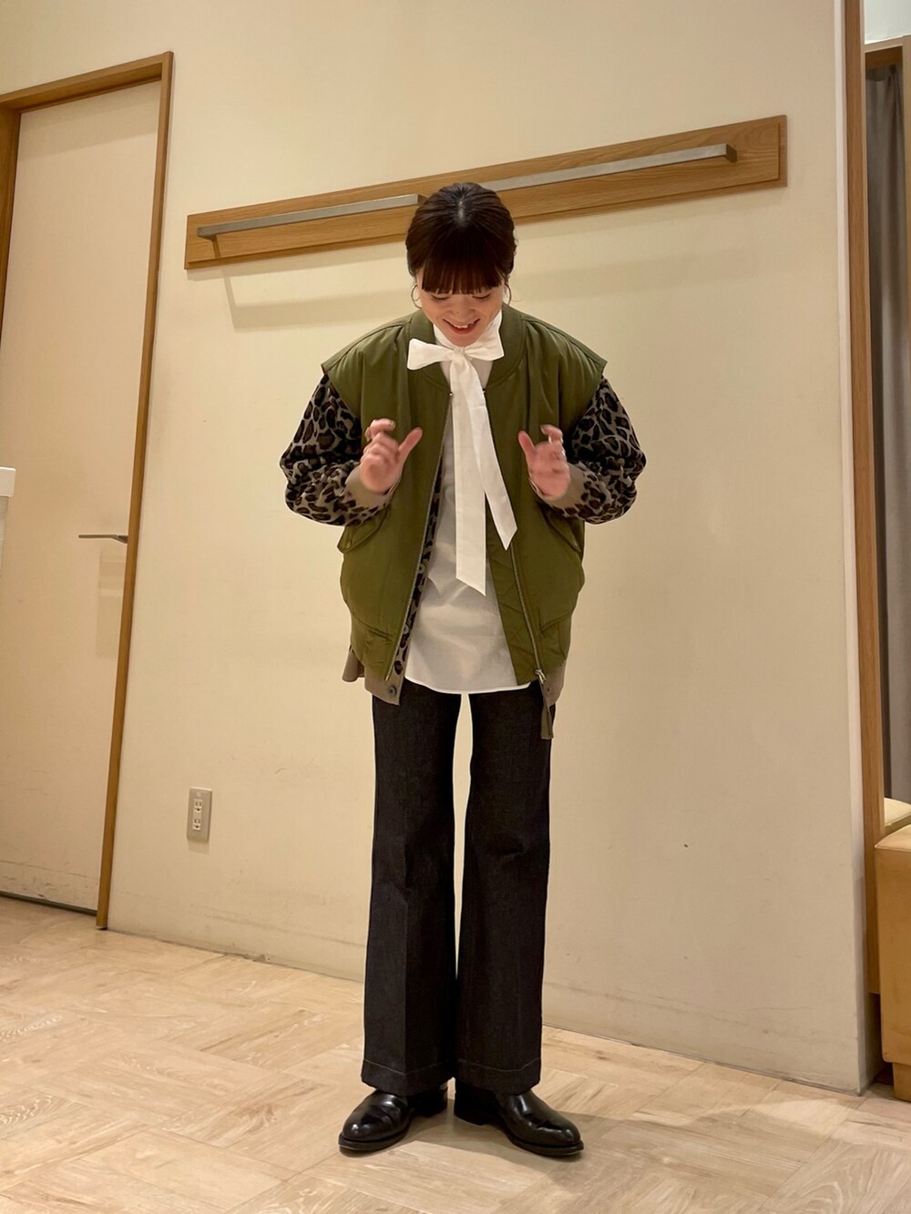 ホワイト系のシャツ/ブラウス、ブルー系のデニムパンツ、ベージュ系のカーディガン/ボレロを着用したレディースの冬コーディネートの2枚目の写真