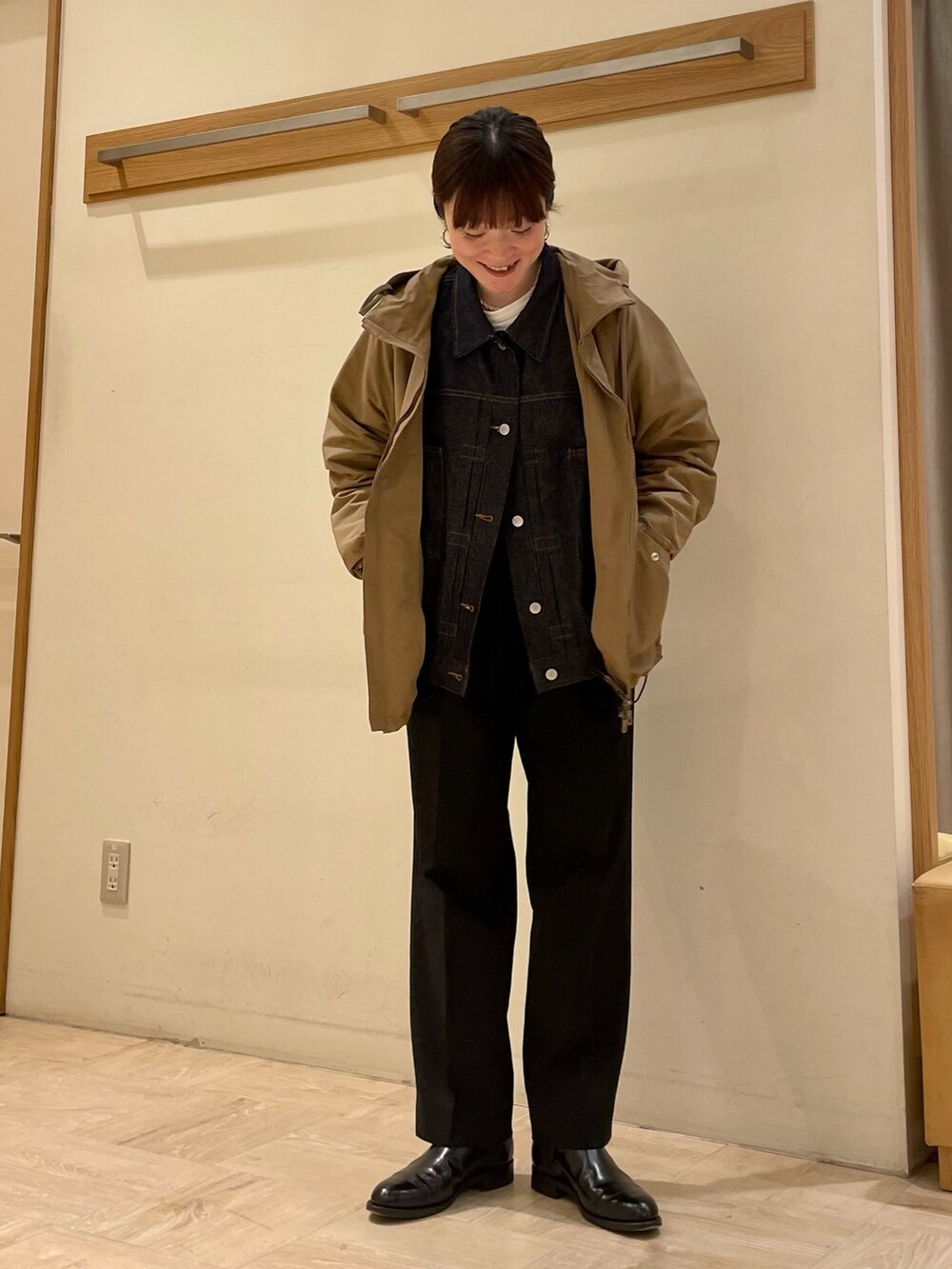 ベージュ系のブルゾン、ブルー系のデニムジャケット、ブラック系のブーツを着用したレディースの冬コーディネートの3枚目の写真