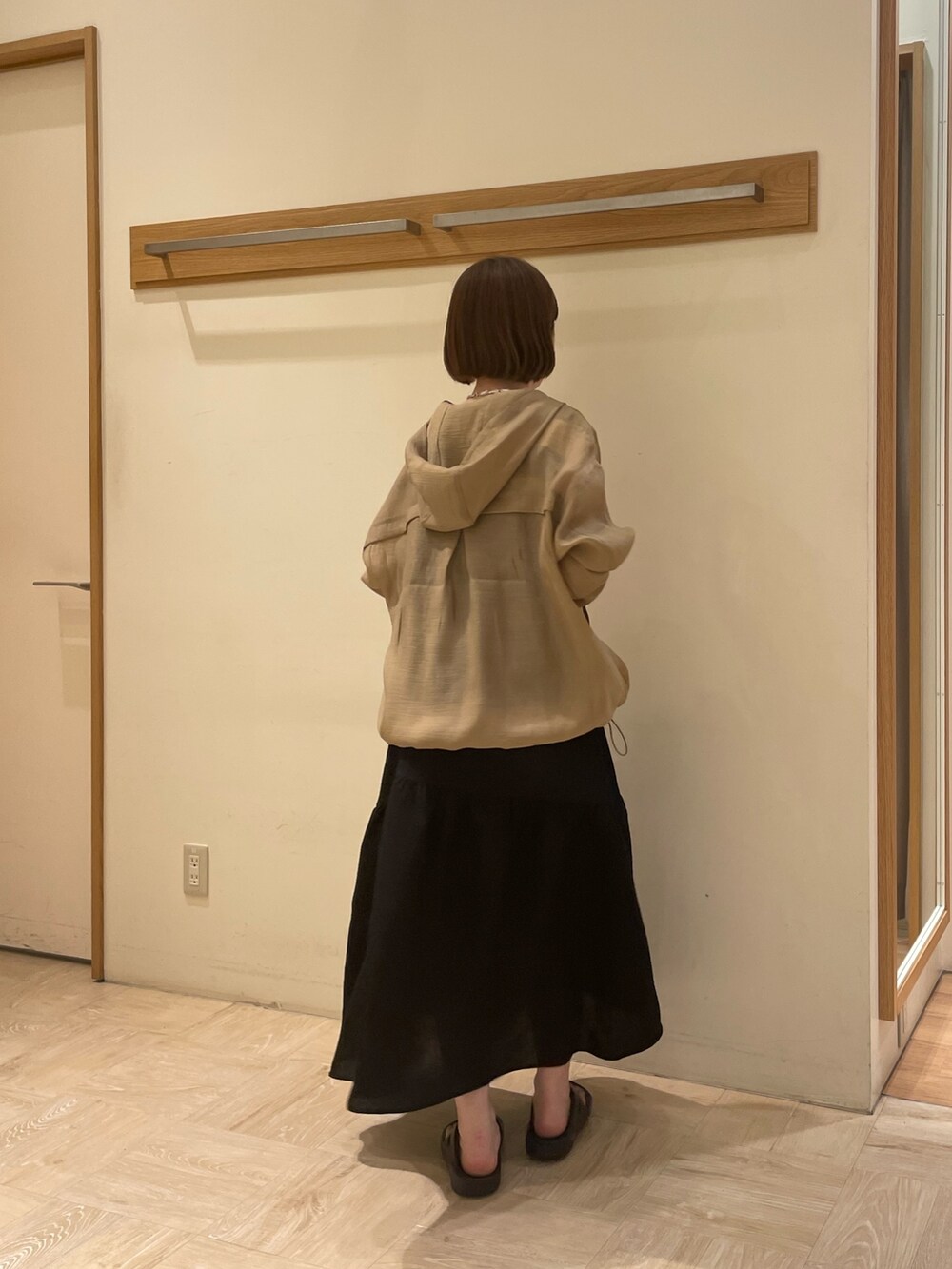 ブラック系のサンダル、ブラック系のワンピース、ベージュ系のブルゾンを着用したレディースの春コーディネートの2枚目の写真