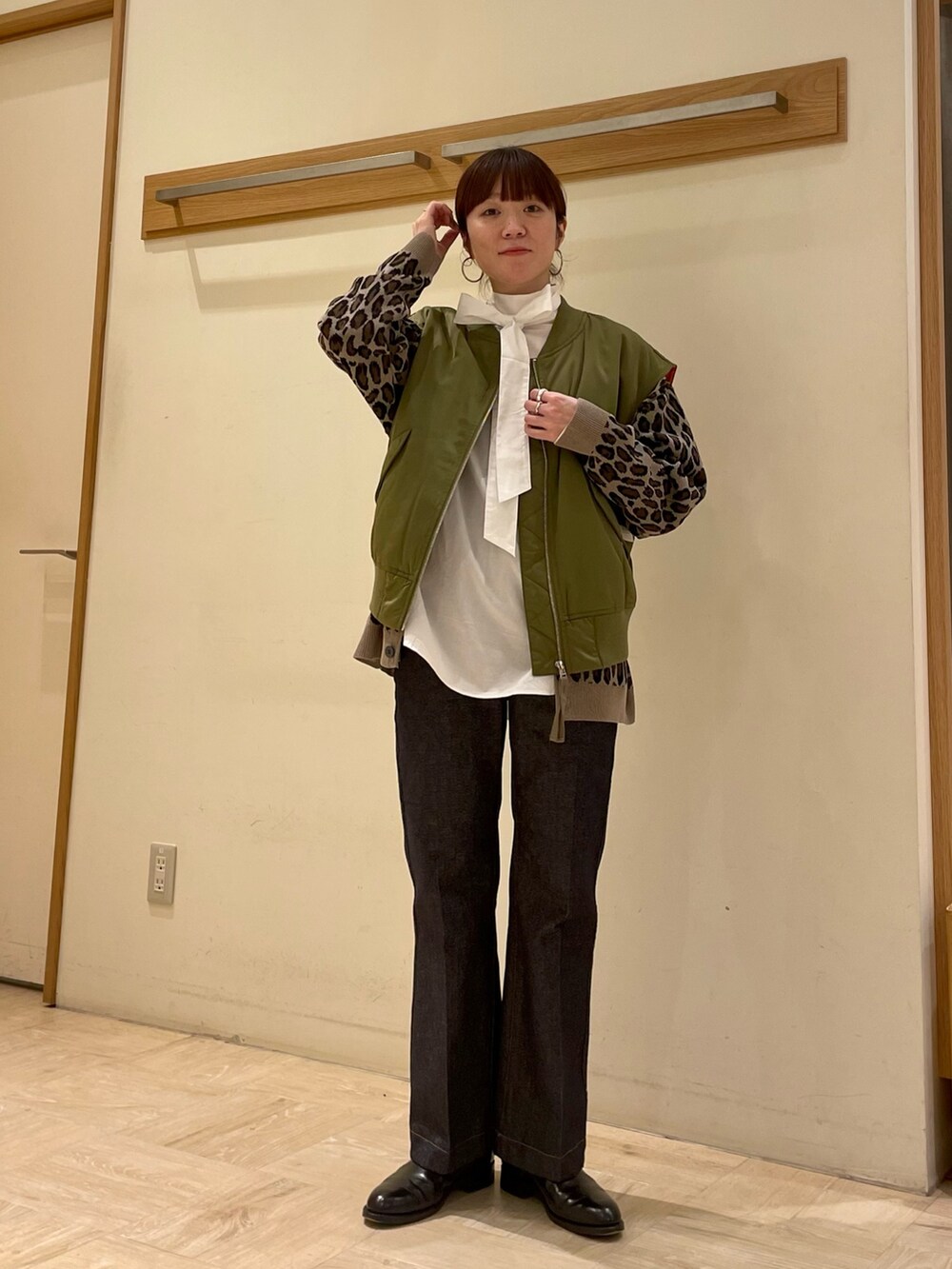 ホワイト系のシャツ/ブラウス、ブルー系のデニムパンツ、ベージュ系のカーディガン/ボレロを着用したレディースの冬コーディネートの3枚目の写真