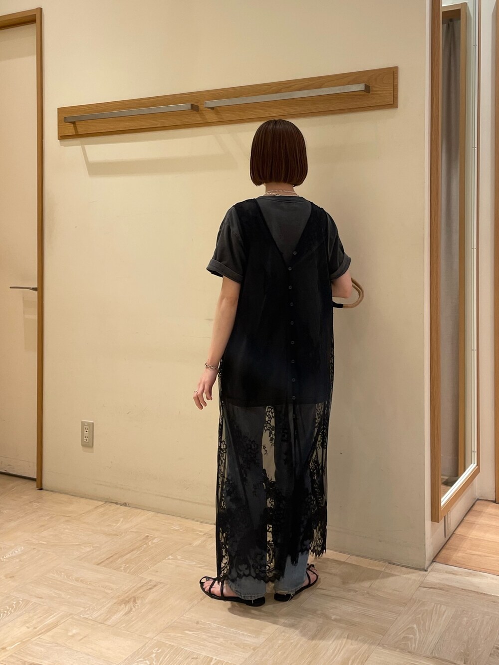 ブルー系のトートバッグ、グレー系のTシャツ/カットソー、ブラック系のベストを着用したレディースの春コーディネートの3枚目の写真