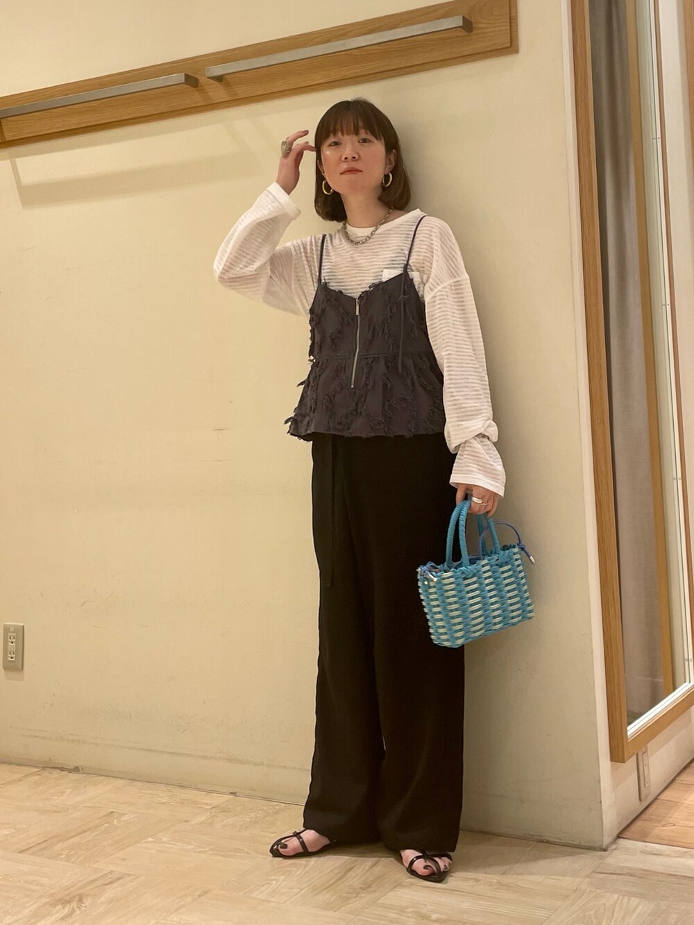 ブラック系のサンダル、ブルー系のショルダーバッグ、ホワイト系のTシャツ/カットソーを着用したレディースの春コーディネートの4枚目の写真