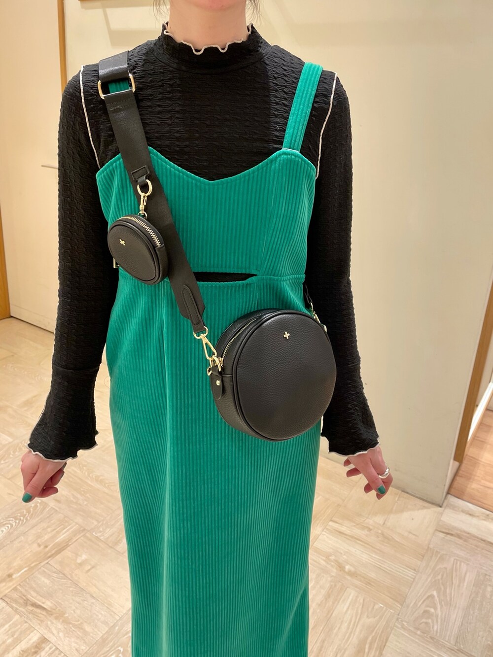 グリーン系のワンピース、ブラック系のブーツ、ブルー系のTシャツ/カットソーを着用したレディースの冬コーディネートの4枚目の写真