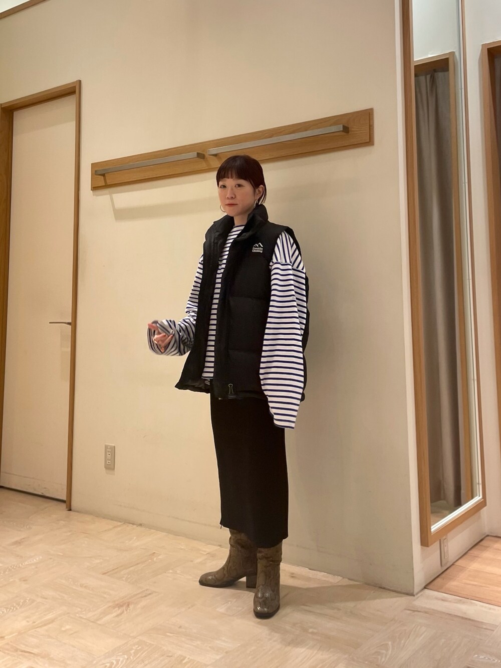 ベージュ系のブーツ、ブラック系のスカート、ホワイト系のTシャツ/カットソーを着用したレディースの冬コーディネートの2枚目の写真