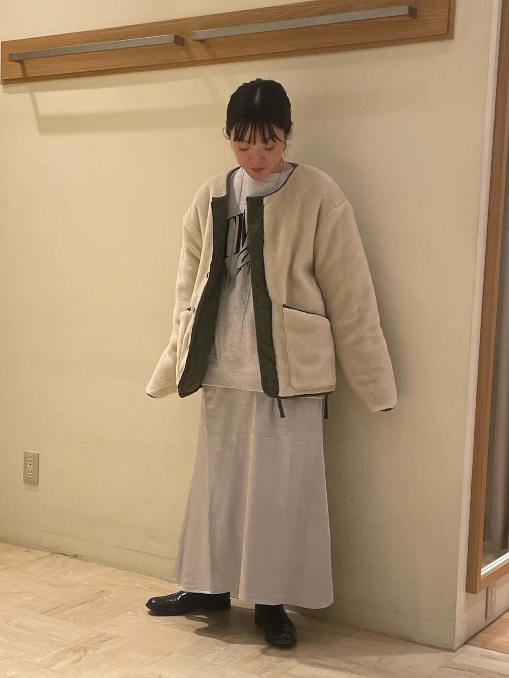 シルバー系のスカート、グリーン系のダウンジャケット/コート、グレー系のスウェットを着用したレディースの秋コーディネートの3枚目の写真