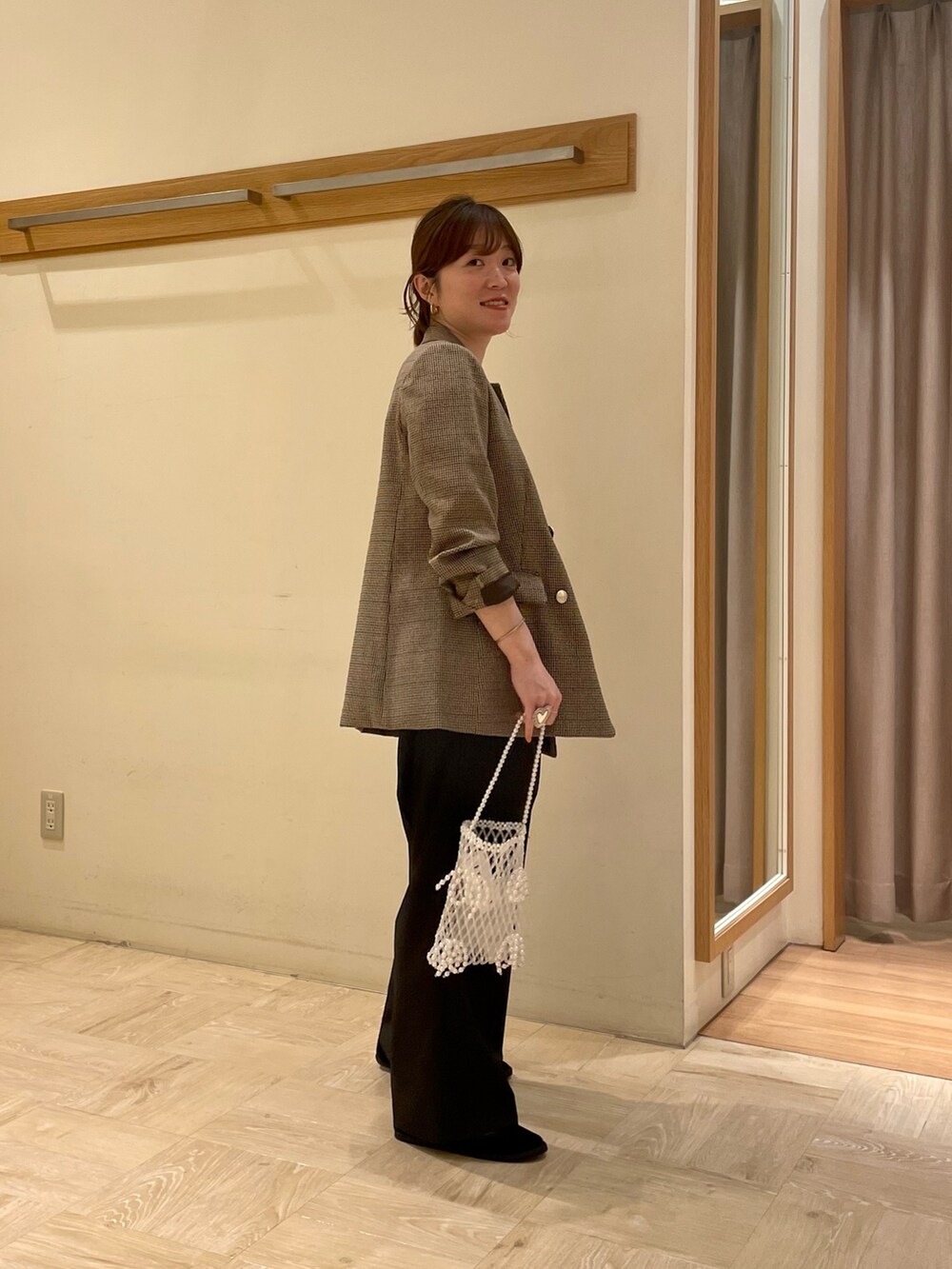 ベージュ系のテーラードジャケット、ホワイト系のTシャツ/カットソー、ブラック系のスラックスを着用したレディースの夏コーディネートの2枚目の写真