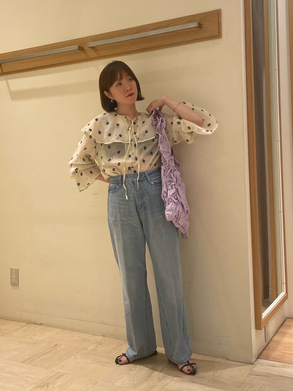 ブルー系のデニムパンツ、ホワイト系のシャツ/ブラウス、パープル系のトートバッグを着用したレディースの秋コーディネートの2枚目の写真