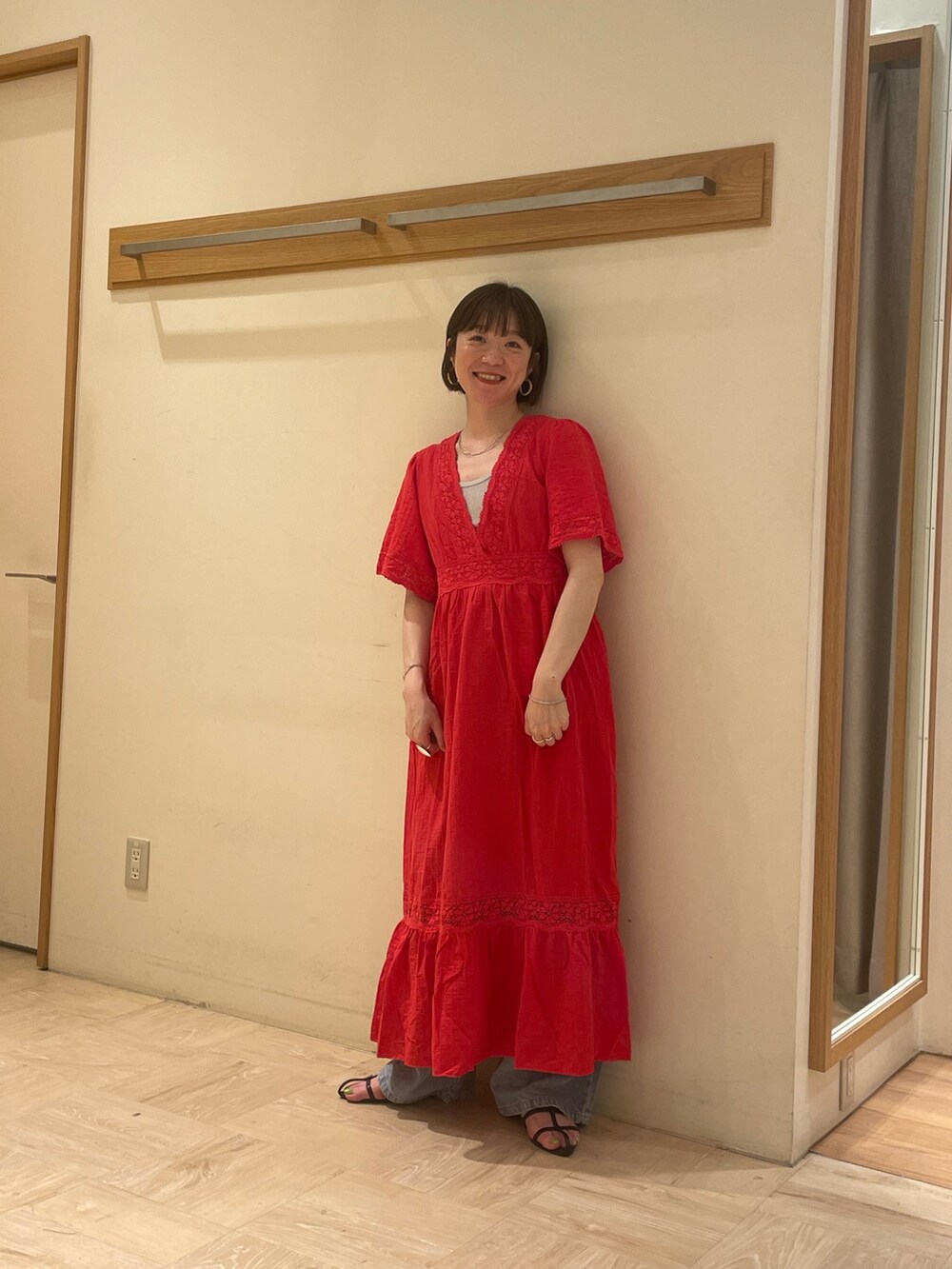 レッド系のワンピース、シルバー系のTシャツ/カットソー、ブルー系のデニムパンツを着用したレディースの夏コーディネートの3枚目の写真