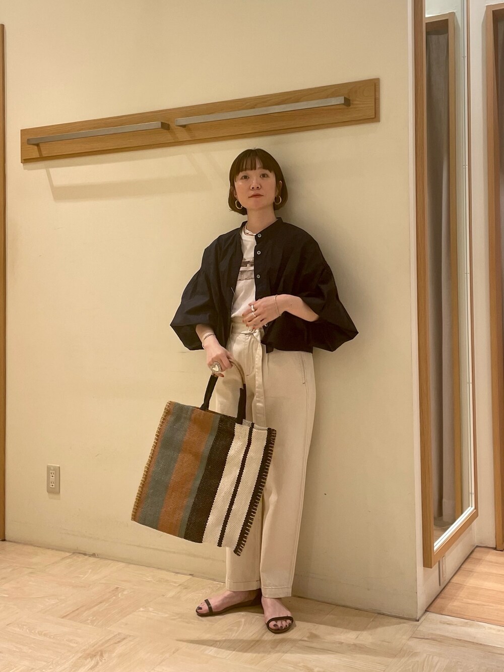 ブラック系のサンダル、ブルー系のシャツ/ブラウス、ホワイト系のデニムパンツを着用したレディースの春コーディネートの4枚目の写真