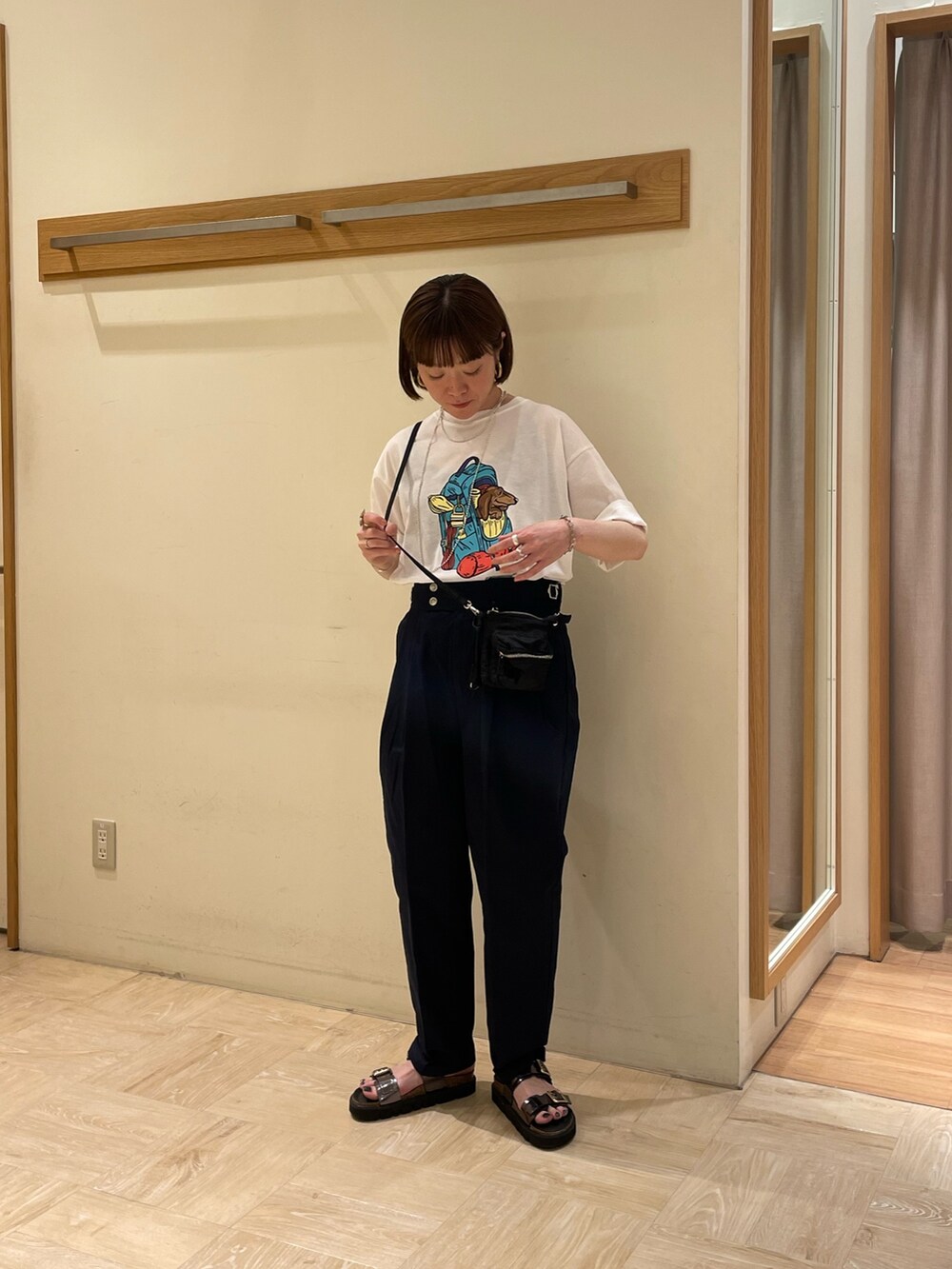 ブラック系のショルダーバッグ、ブルー系のその他パンツ、ホワイト系のTシャツ/カットソーを着用したレディースの春コーディネートの2枚目の写真