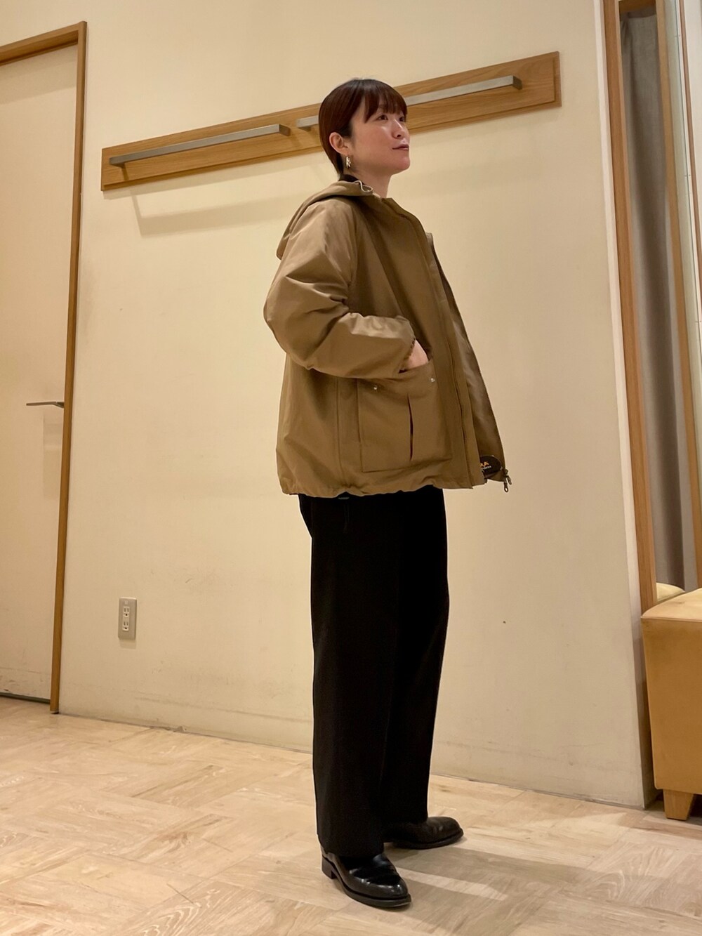 ベージュ系のブルゾン、ブルー系のデニムジャケット、ブラック系のブーツを着用したレディースの冬コーディネートの2枚目の写真