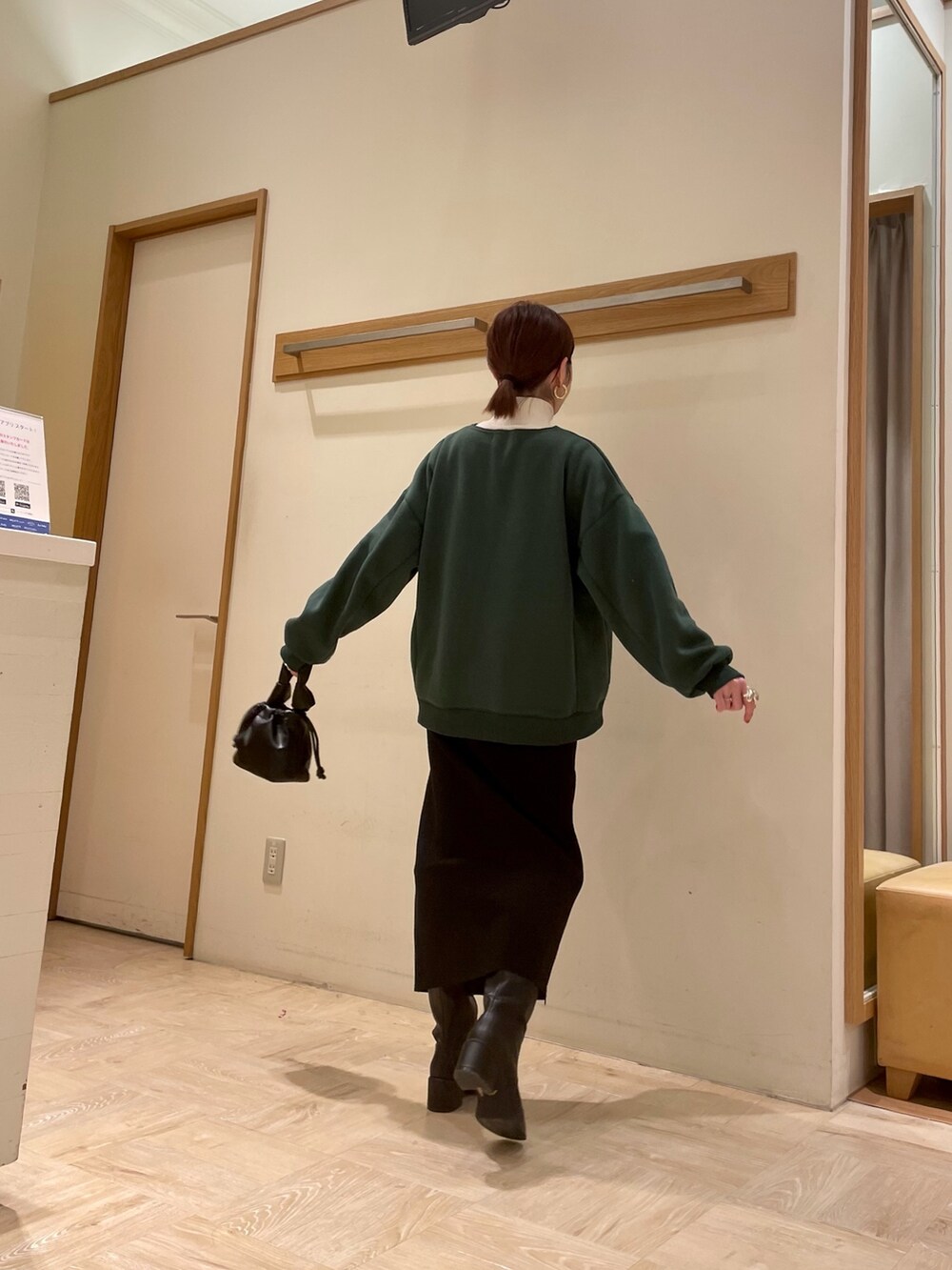 ブラック系のブーツ、ブラック系のスカート、グリーン系のスウェットを着用したレディースの冬コーディネートの2枚目の写真