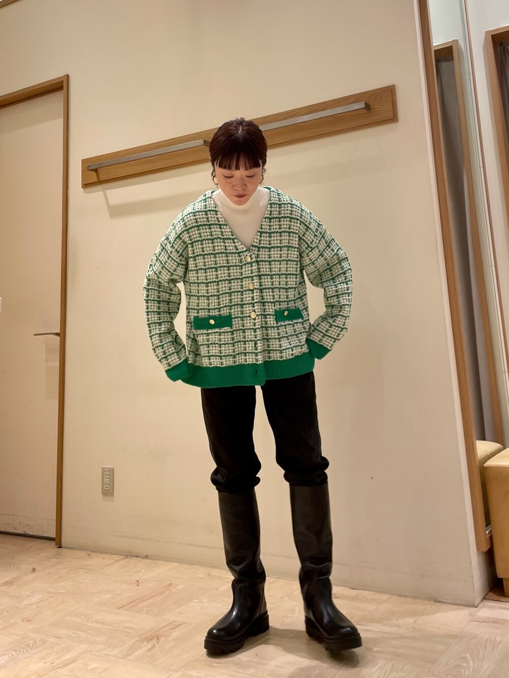 ブラック系のブーツ、グリーン系のカーディガン/ボレロ、ホワイト系のTシャツ/カットソーを着用したレディースの冬コーディネートの3枚目の写真