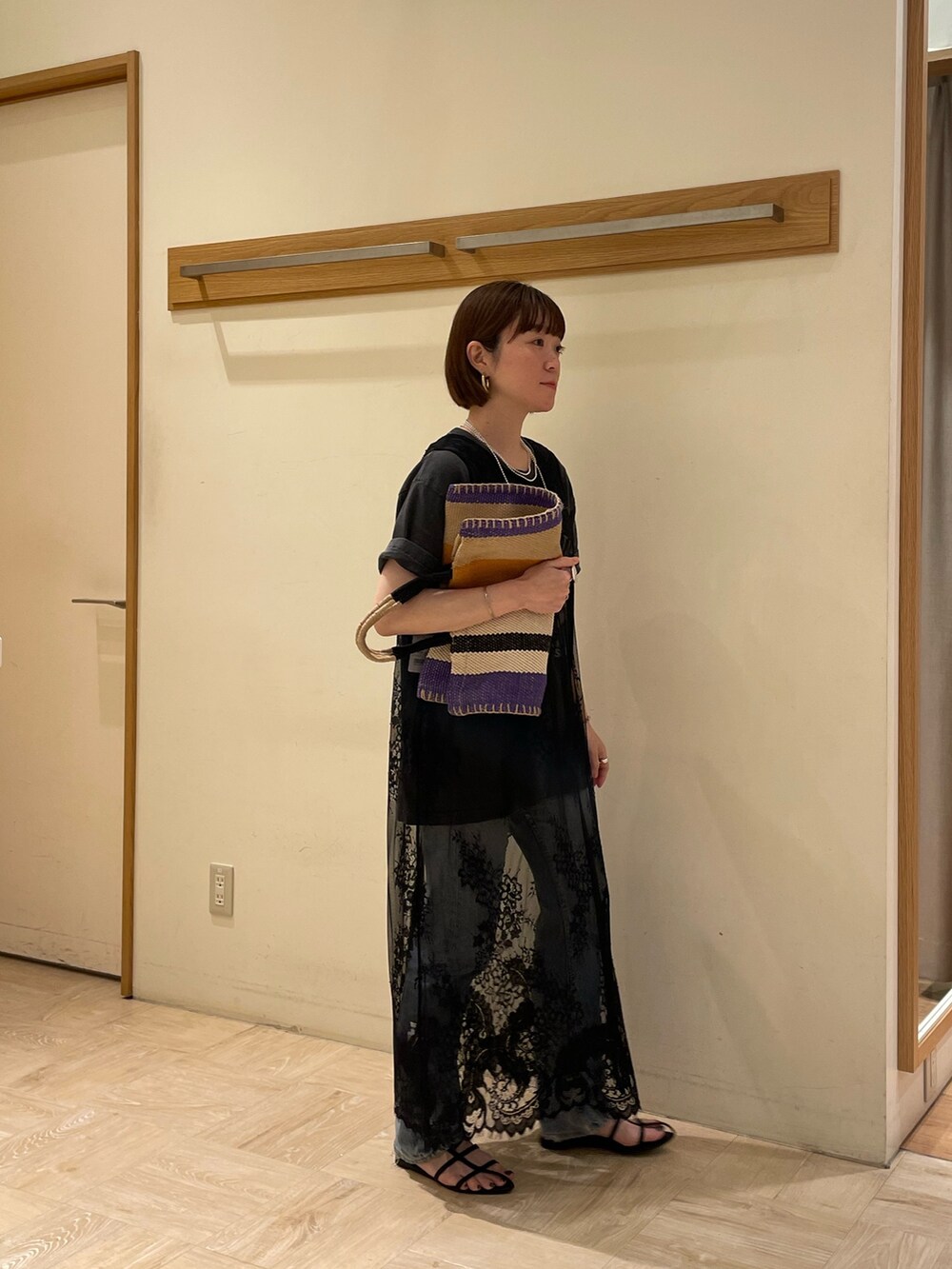 ブルー系のトートバッグ、グレー系のTシャツ/カットソー、ブラック系のベストを着用したレディースの春コーディネートの4枚目の写真