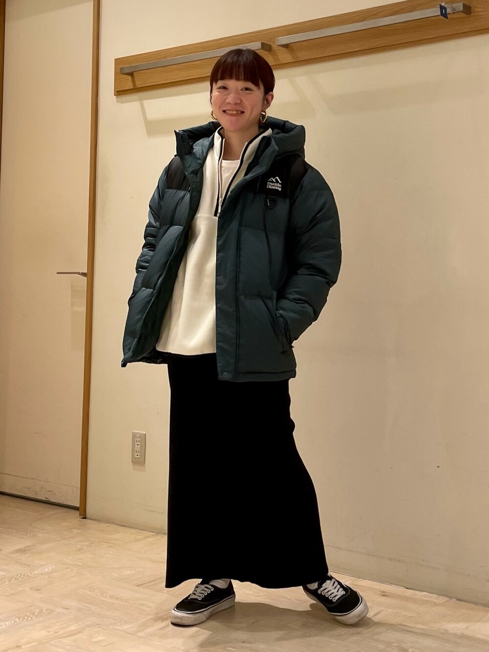 ホワイト系のスウェット、グリーン系のダウンジャケット/コートを着用したレディースの冬コーディネートの2枚目の写真