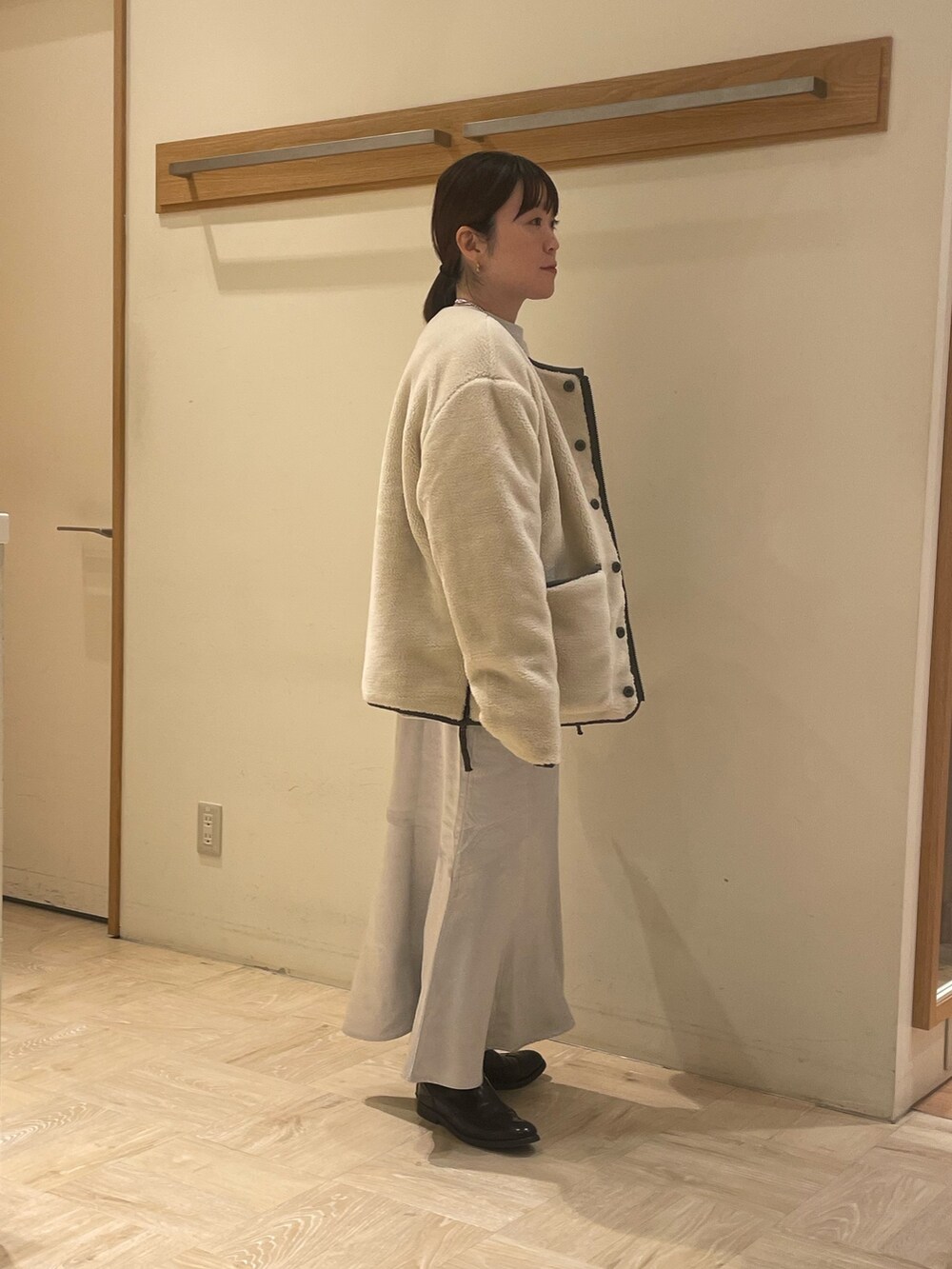 シルバー系のスカート、グリーン系のダウンジャケット/コート、グレー系のスウェットを着用したレディースの秋コーディネートの2枚目の写真