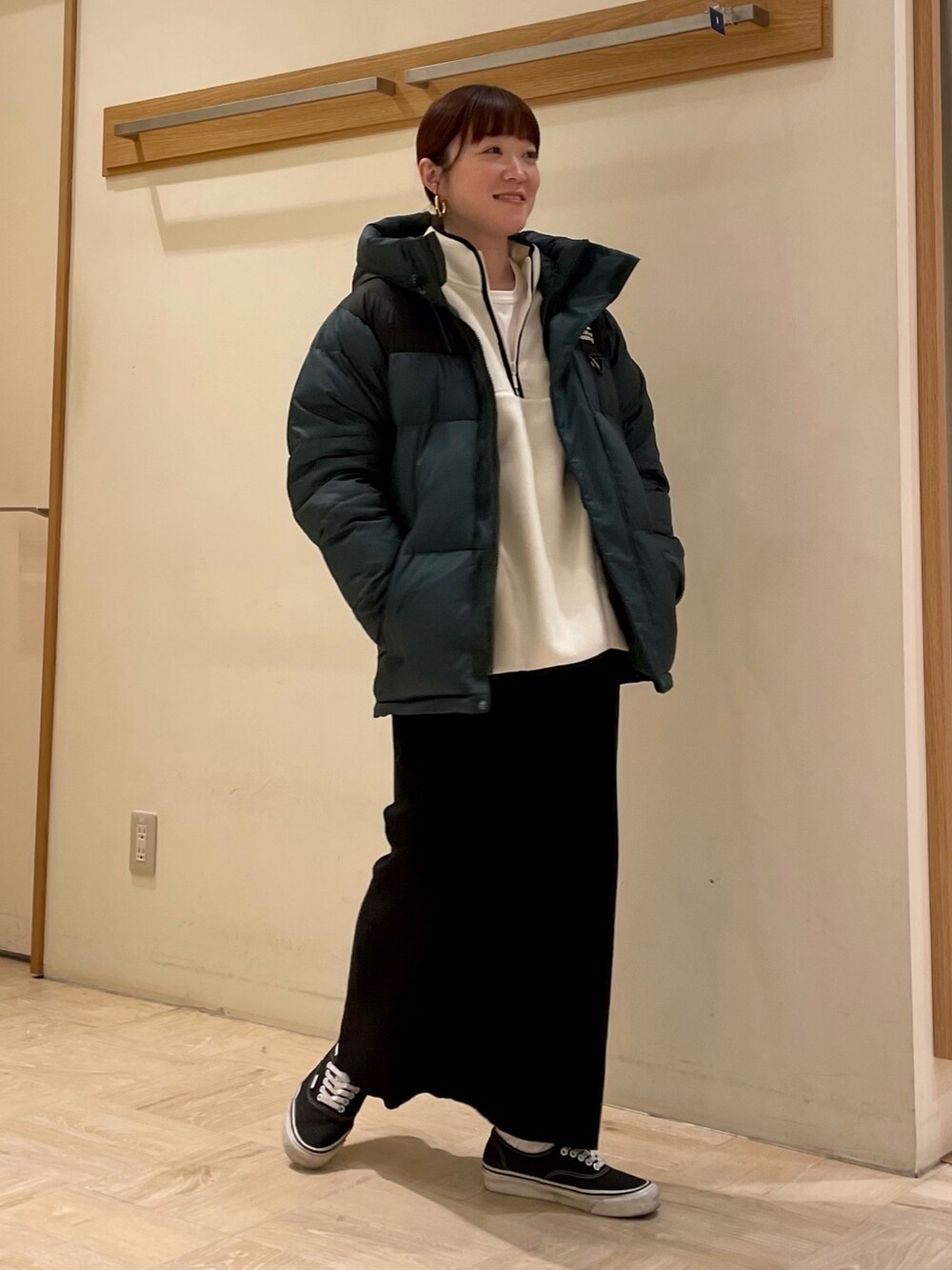 ホワイト系のスウェット、グリーン系のダウンジャケット/コートを着用したレディースの冬コーディネートの3枚目の写真