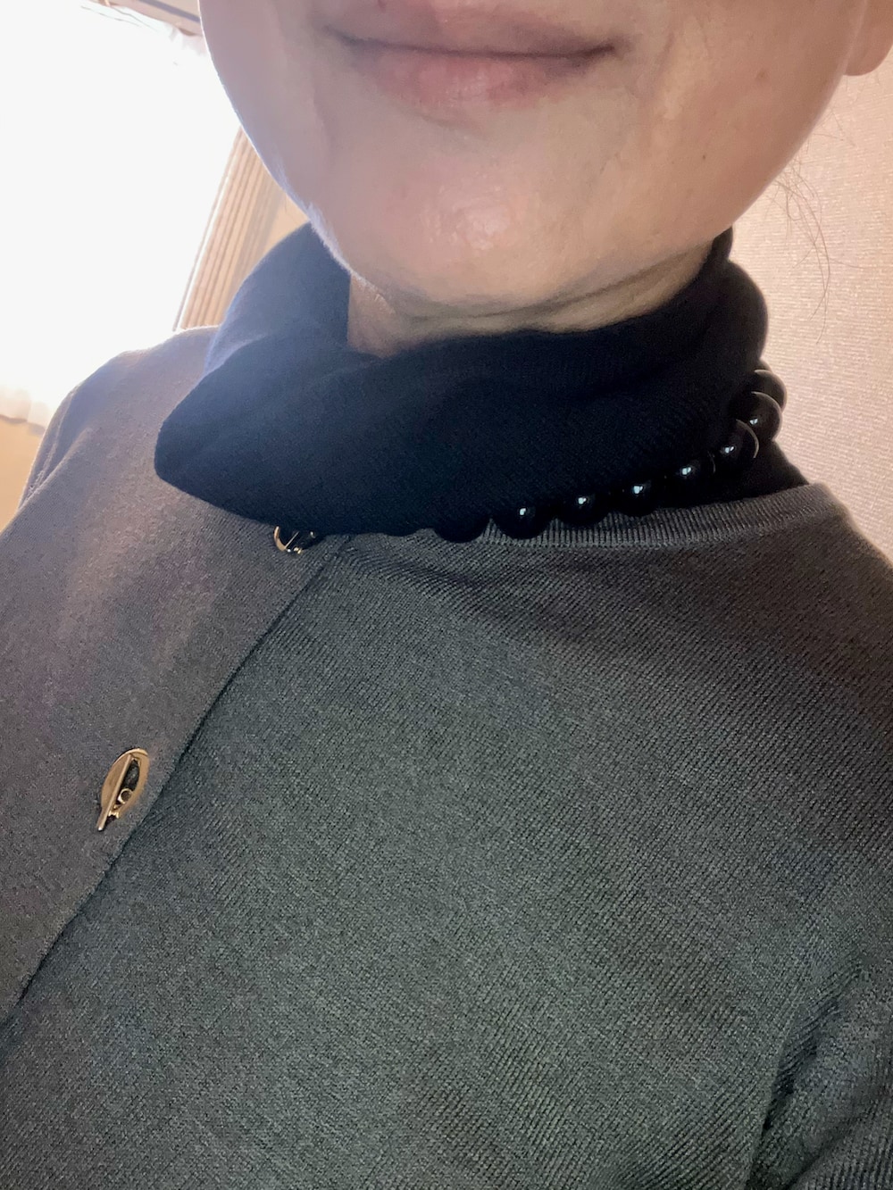 グレー系のカーディガン/ボレロ、グレー系のスラックス、ブラック系のニット/セーターを着用したレディースの秋コーディネートの2枚目の写真