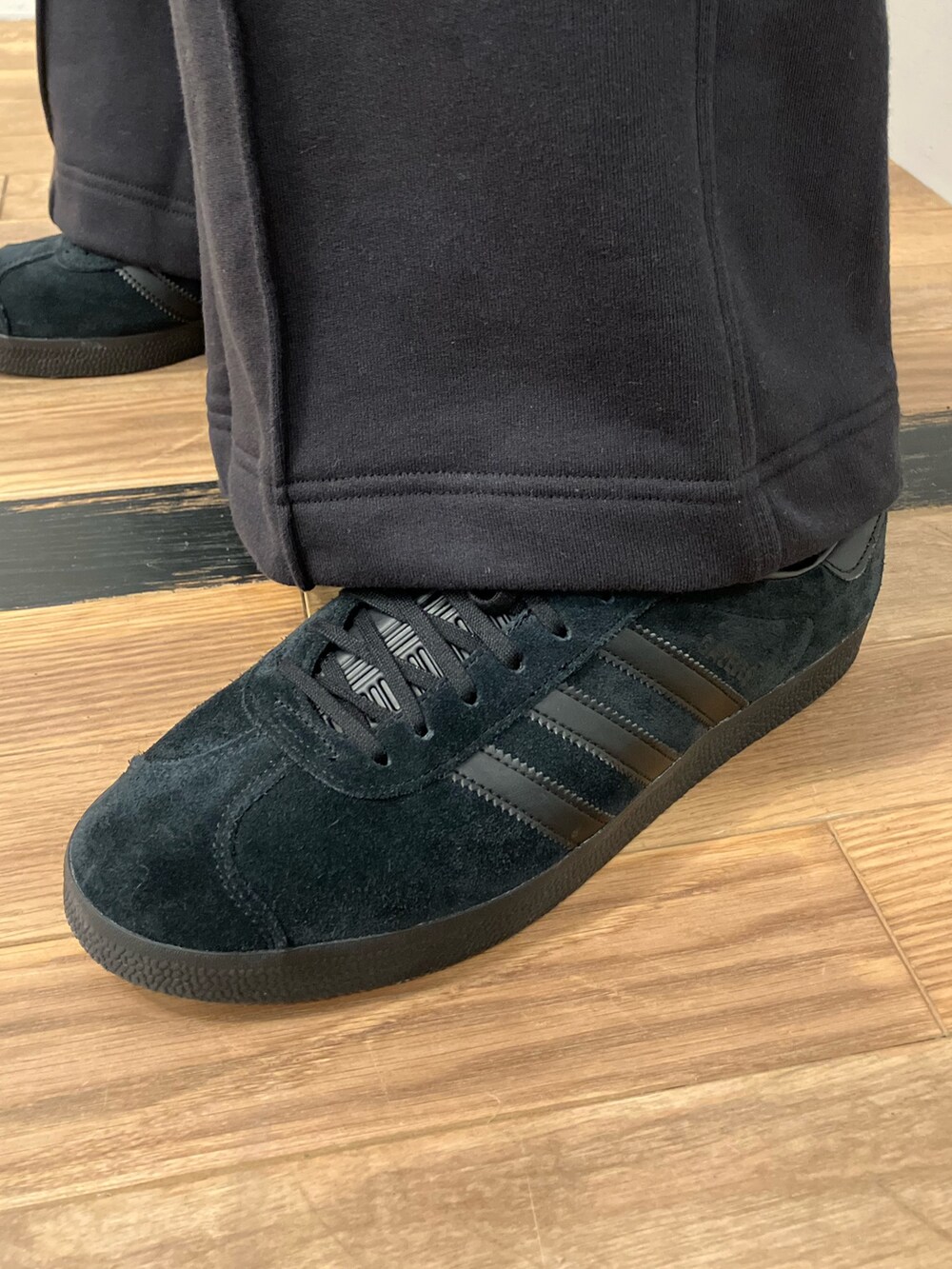 グリーン系のジャージ、ブラック系のTシャツ/カットソー、ブラック系のスウェットパンツを着用したメンズの秋コーディネートの5枚目の写真