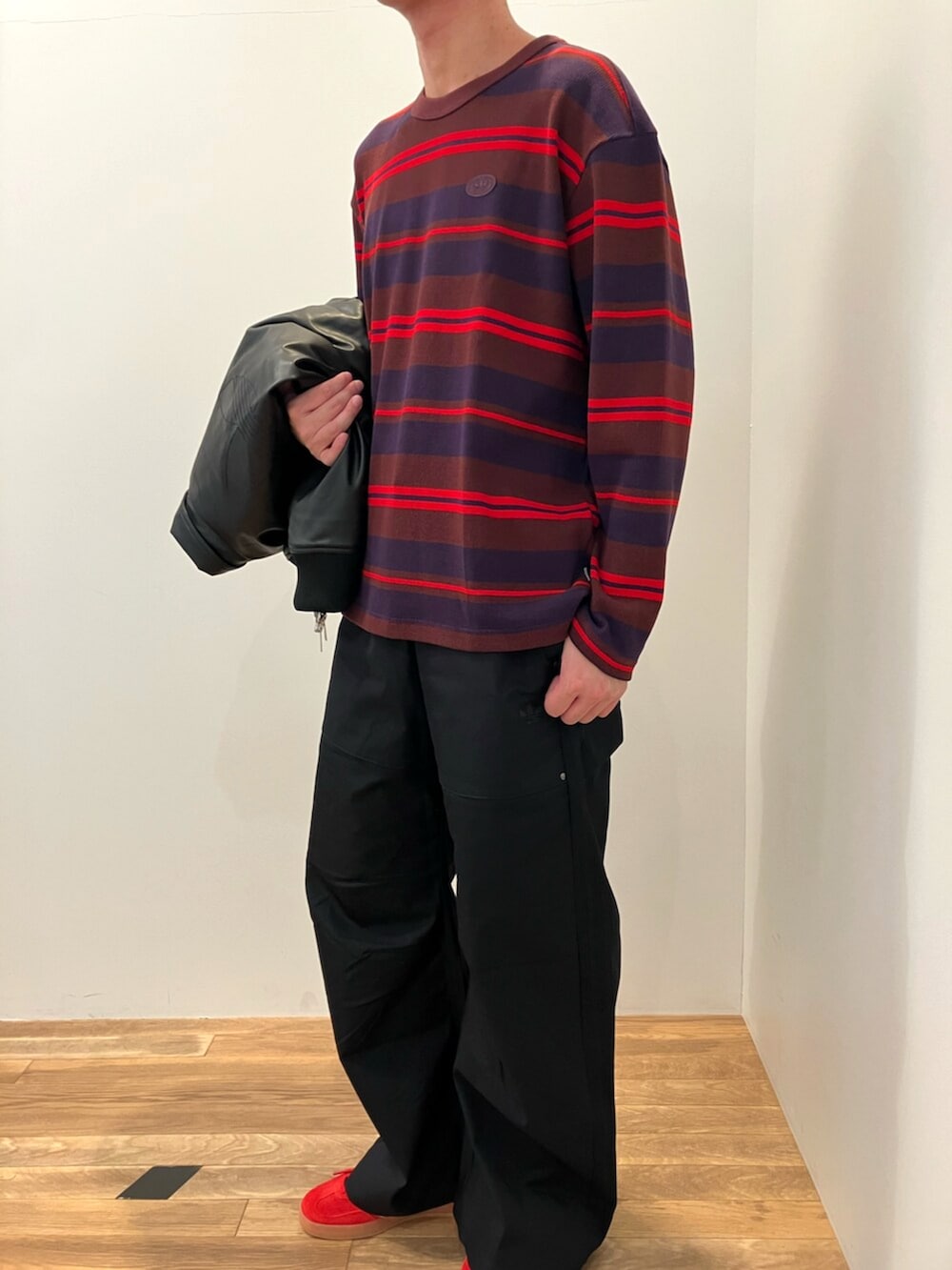 レッド系のTシャツ/カットソー、ブラック系のブルゾン、ブラック系のその他パンツを着用したメンズの冬コーディネートの3枚目の写真