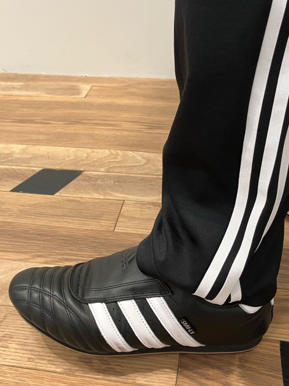 ブラウン系のパーカー、ブラック系のスウェットパンツ、ブラック系のシューズを着用したメンズの冬コーディネートの4枚目の写真