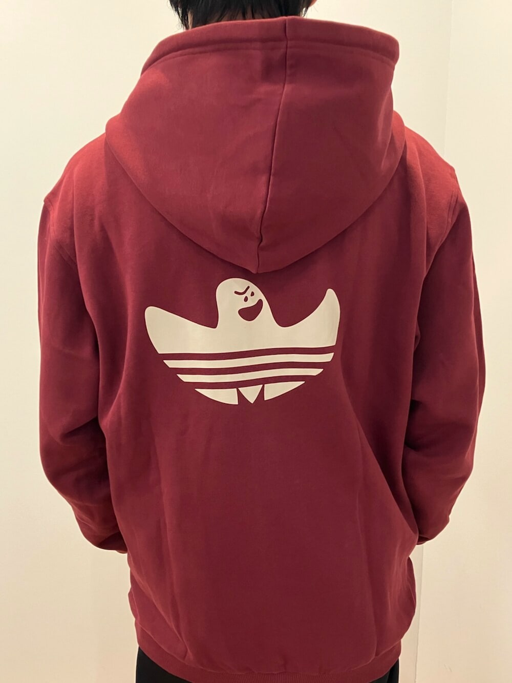 レッド系のパーカー、ブラック系のスウェットパンツ、ブラック系のスニーカーを着用したメンズの冬コーディネートの2枚目の写真