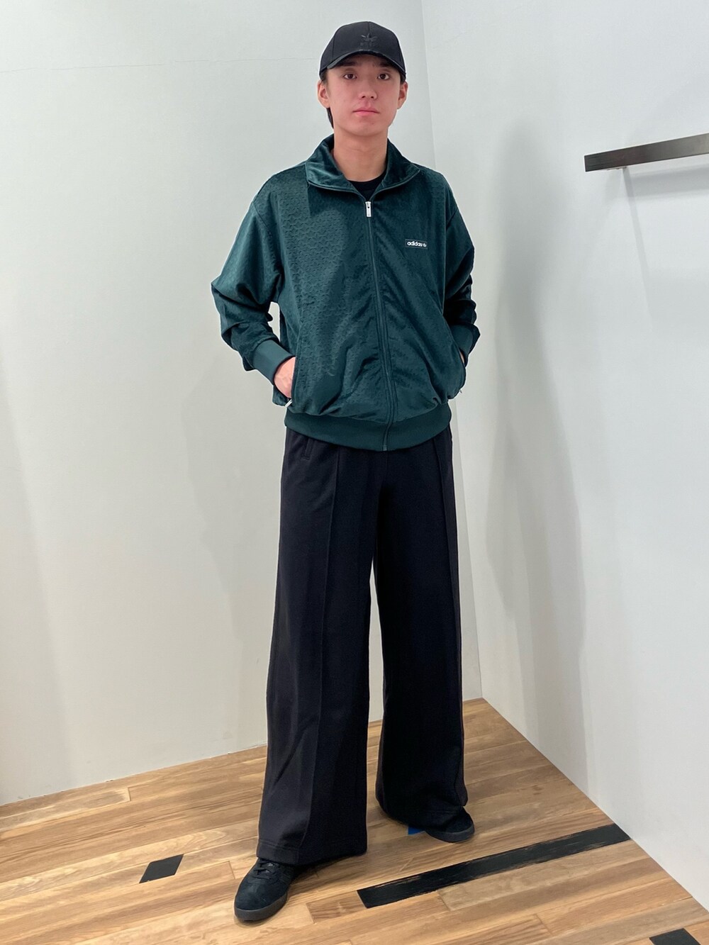 グリーン系のジャージ、ブラック系のTシャツ/カットソー、ブラック系のスウェットパンツを着用したメンズの秋コーディネートの3枚目の写真