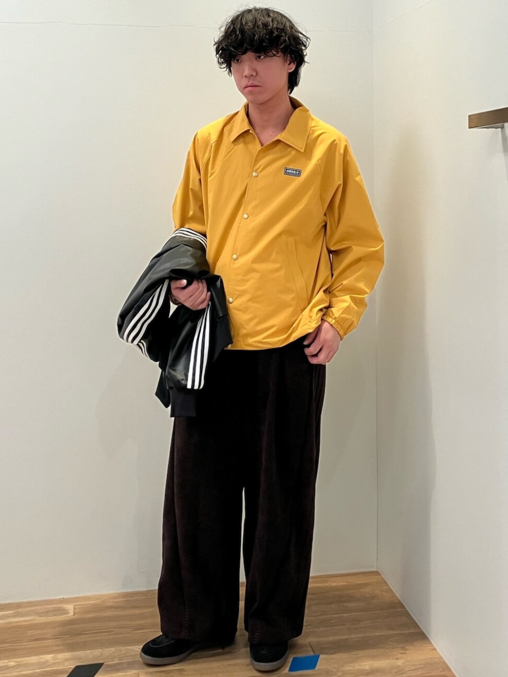 ブラック系のスニーカー、イエロー系のブルゾン、ブラック系のブルゾンを着用したメンズの冬コーディネートの2枚目の写真