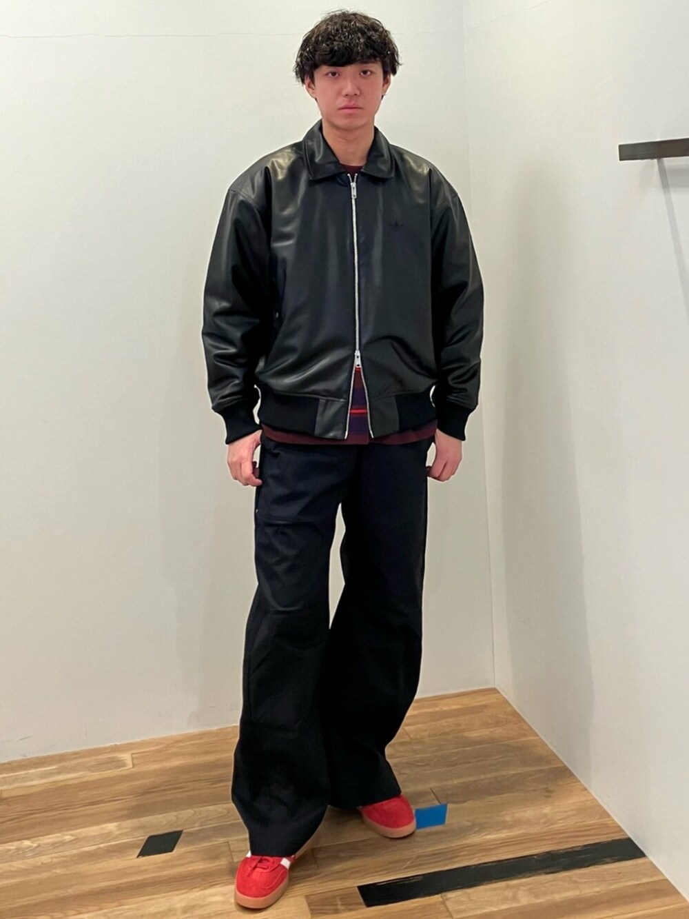 レッド系のTシャツ/カットソー、ブラック系のブルゾン、ブラック系のその他パンツを着用したメンズの冬コーディネートの2枚目の写真