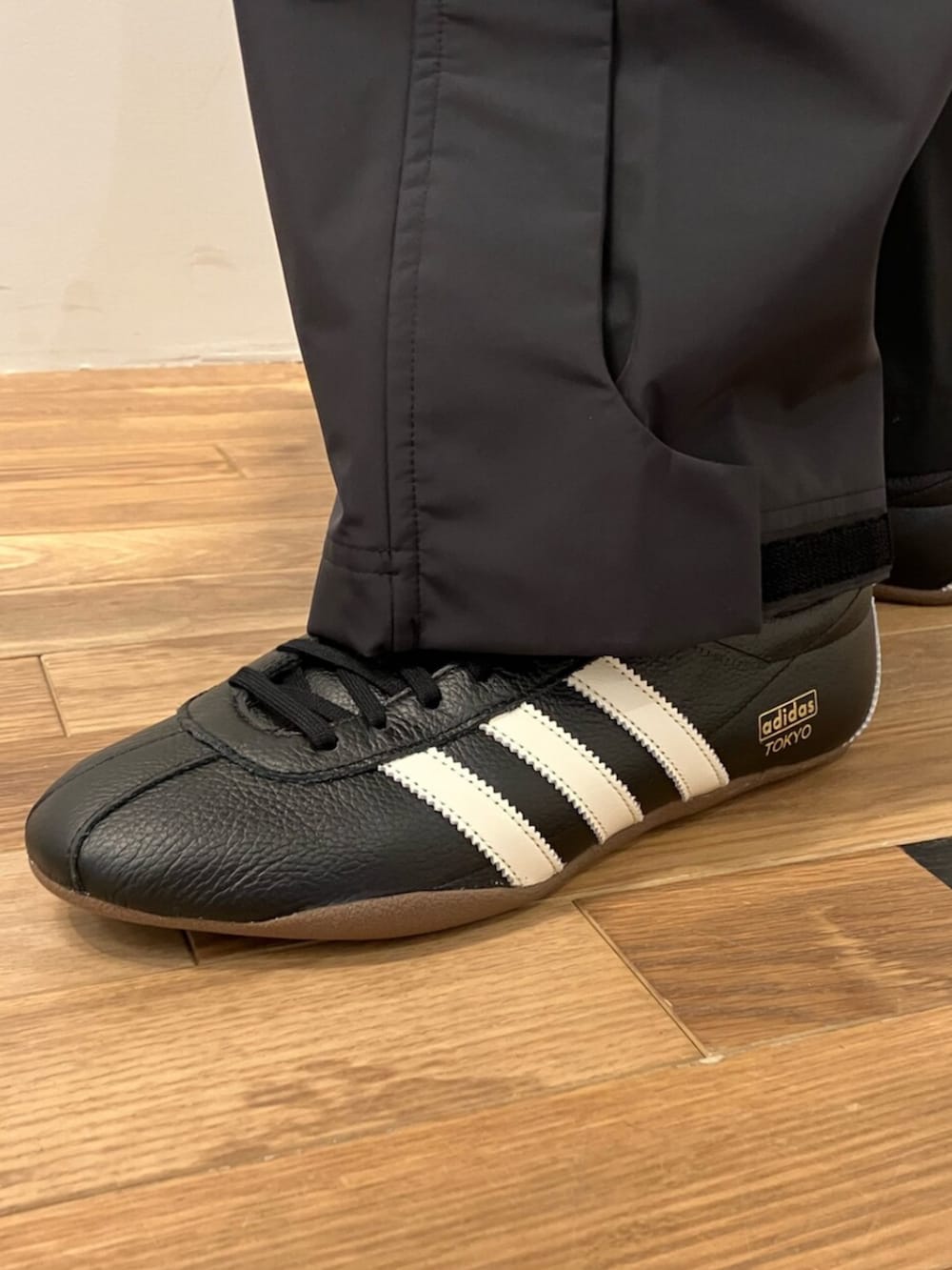 ブラック系のパーカー、ホワイト系のTシャツ/カットソー、ブラック系のスニーカーを着用したメンズの冬コーディネートの4枚目の写真