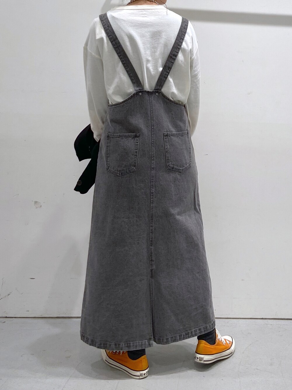 ホワイト系のTシャツ/カットソー、ブラック系のカーディガン/ボレロ、オレンジ系のスニーカーを着用したレディースの春コーディネートの4枚目の写真