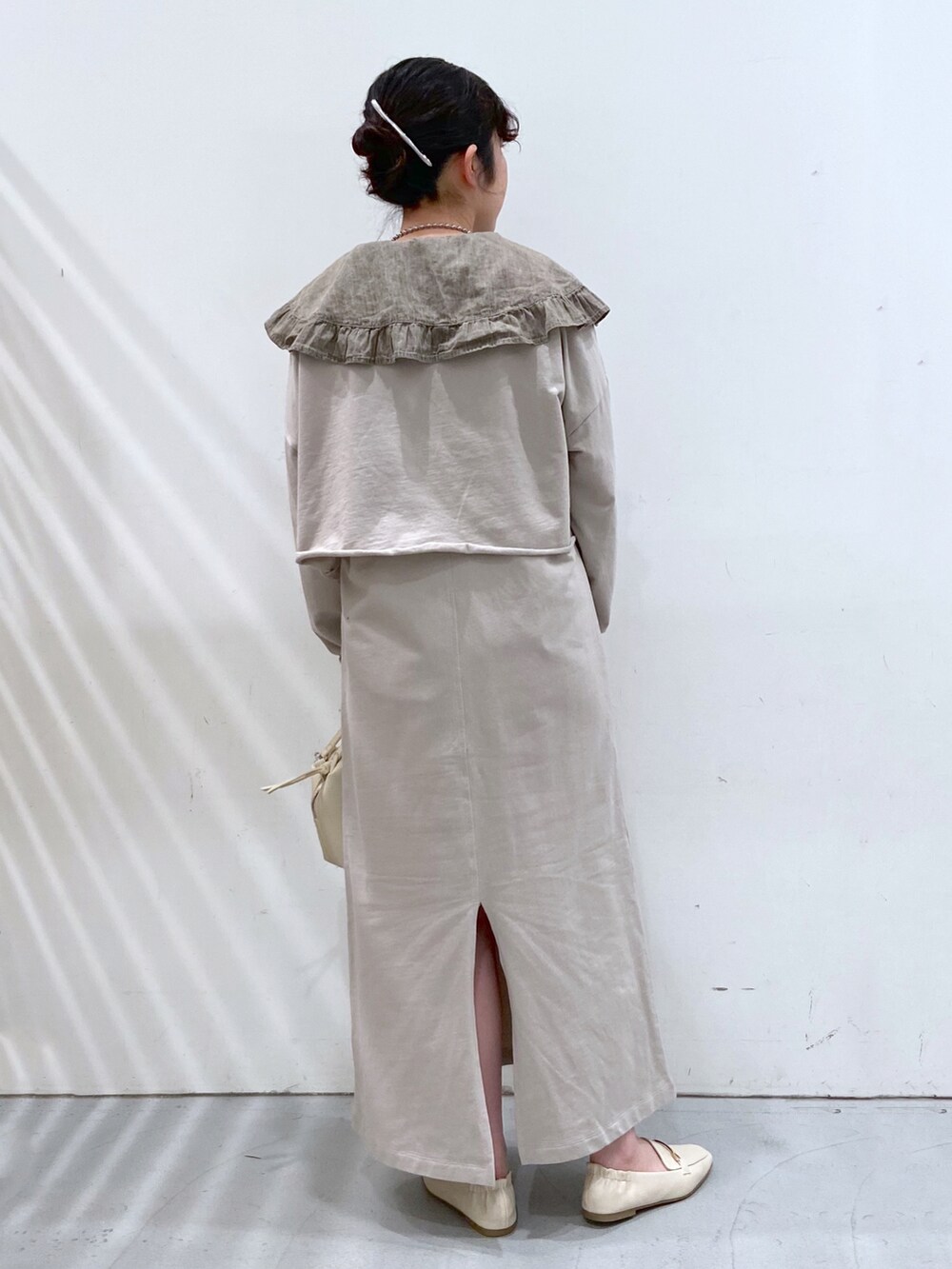 グレー系のワンピース、グレー系のシャツ/ブラウス、ホワイト系のショルダーバッグを着用したレディースの春コーディネートの3枚目の写真