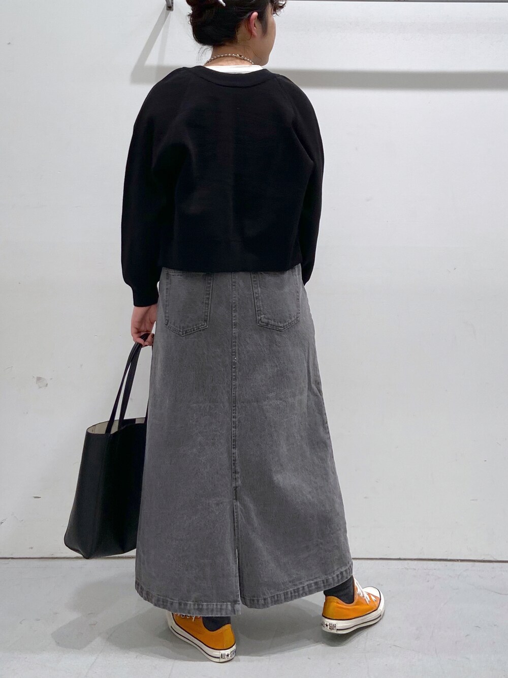 ホワイト系のTシャツ/カットソー、ブラック系のカーディガン/ボレロ、オレンジ系のスニーカーを着用したレディースの春コーディネートの2枚目の写真