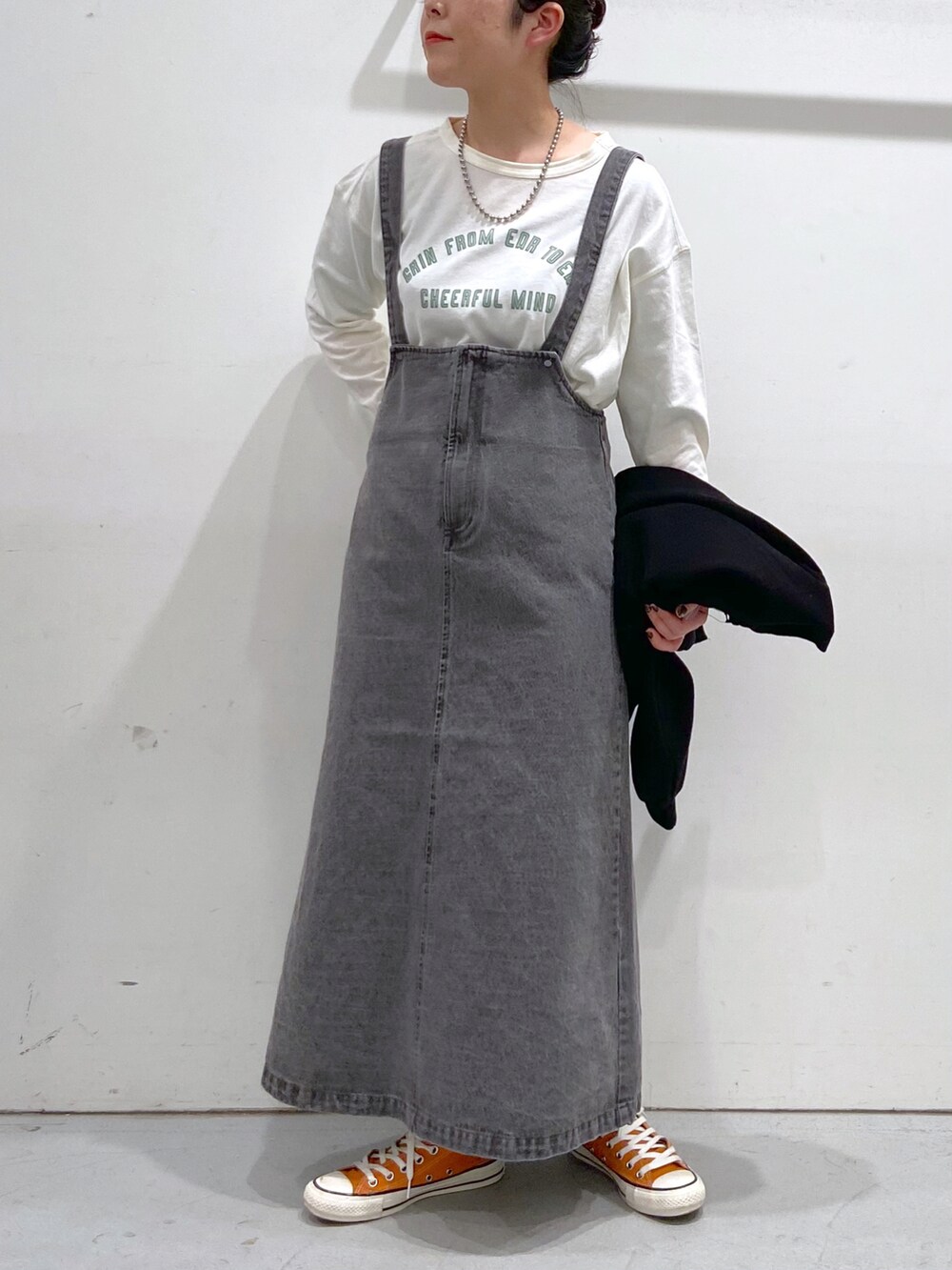 ホワイト系のTシャツ/カットソー、ブラック系のカーディガン/ボレロ、オレンジ系のスニーカーを着用したレディースの春コーディネートの3枚目の写真