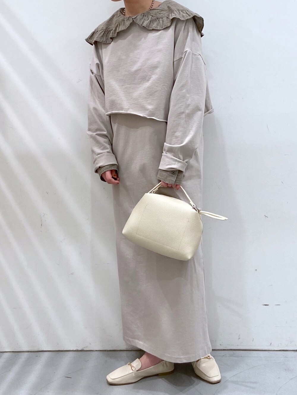 グレー系のワンピース、グレー系のシャツ/ブラウス、ホワイト系のショルダーバッグを着用したレディースの春コーディネートの2枚目の写真