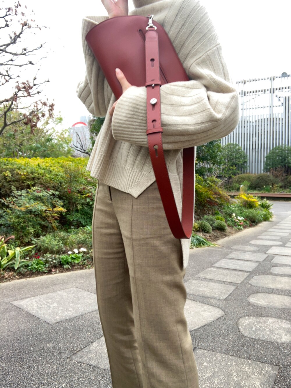 ベージュ系のパンツ、ブラック系のサンダル、ベージュ系のニット/セーターを着用したレディースの冬コーディネートの2枚目の写真