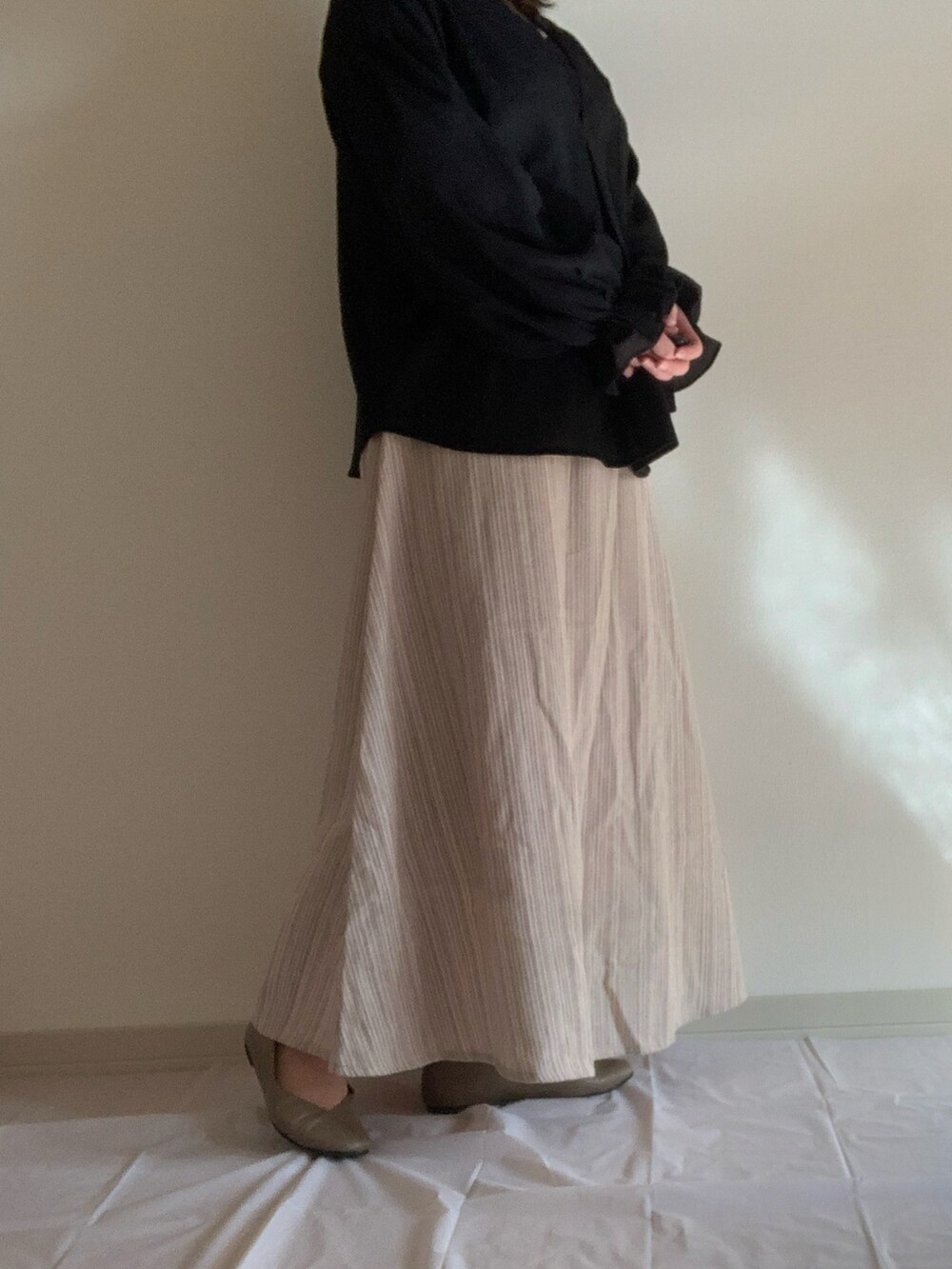 ブラック系のシャツ/ブラウス、ブラウン系のスカートを着用したレディースの秋コーディネートの2枚目の写真