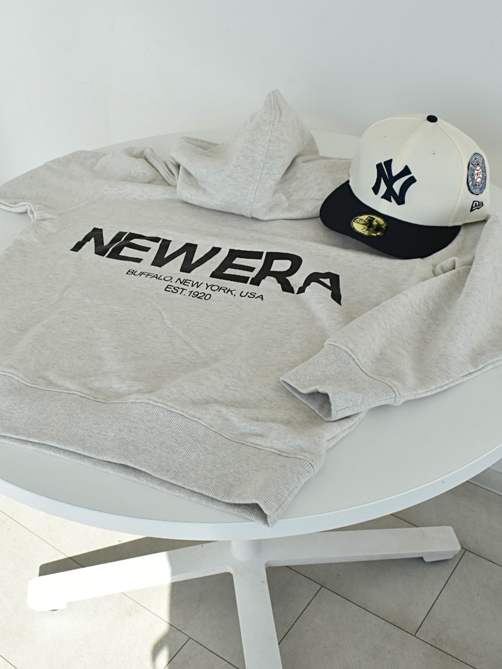 ブラック系のブーツ、ホワイト系のパーカー、ベージュ系のパンツを着用したメンズの秋コーディネートの5枚目の写真