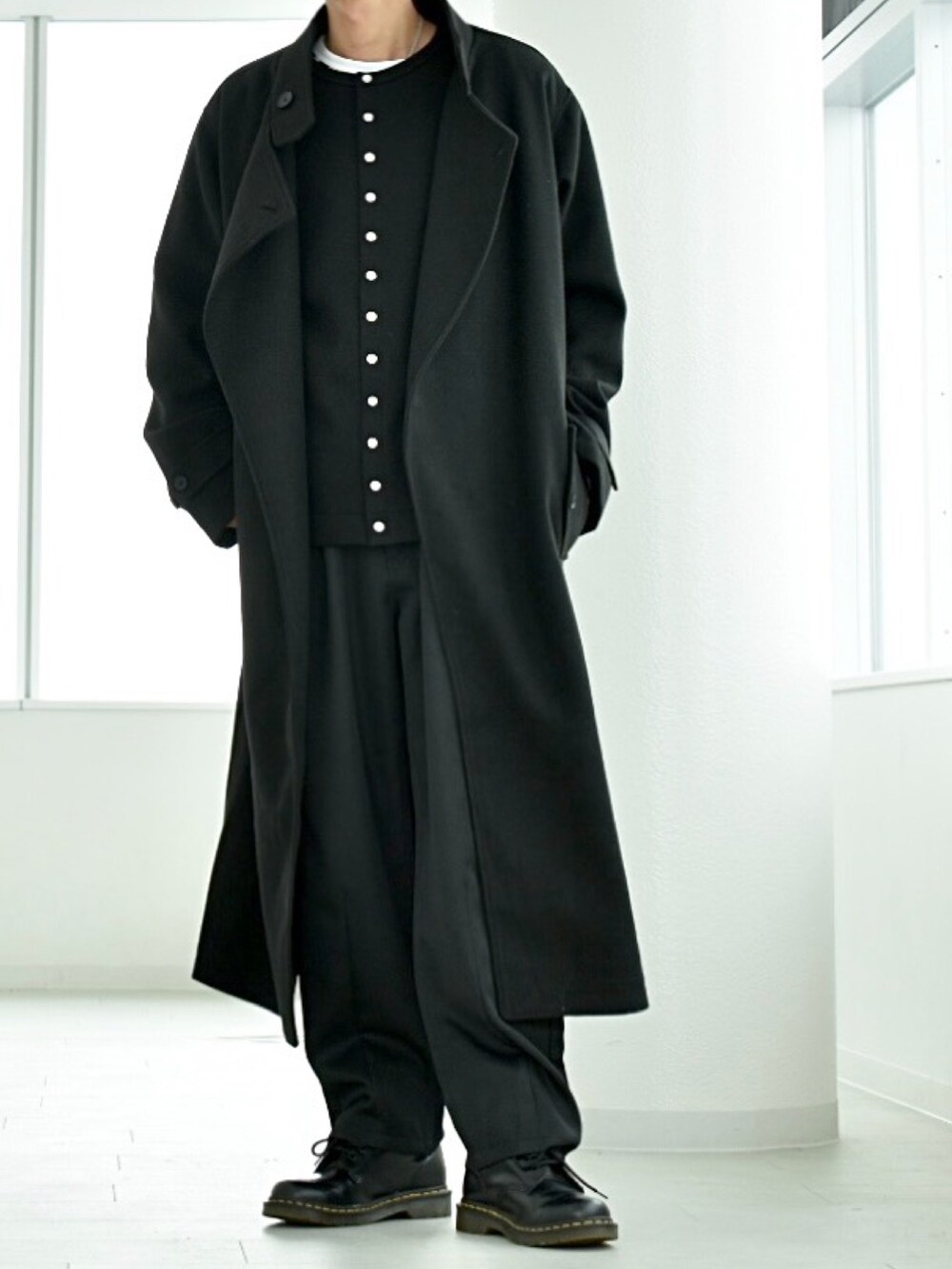 ブラック系のカーディガン/ボレロ、ブラック系のチェスターコート、ブラック系のスラックスを着用したメンズの冬コーディネートの2枚目の写真