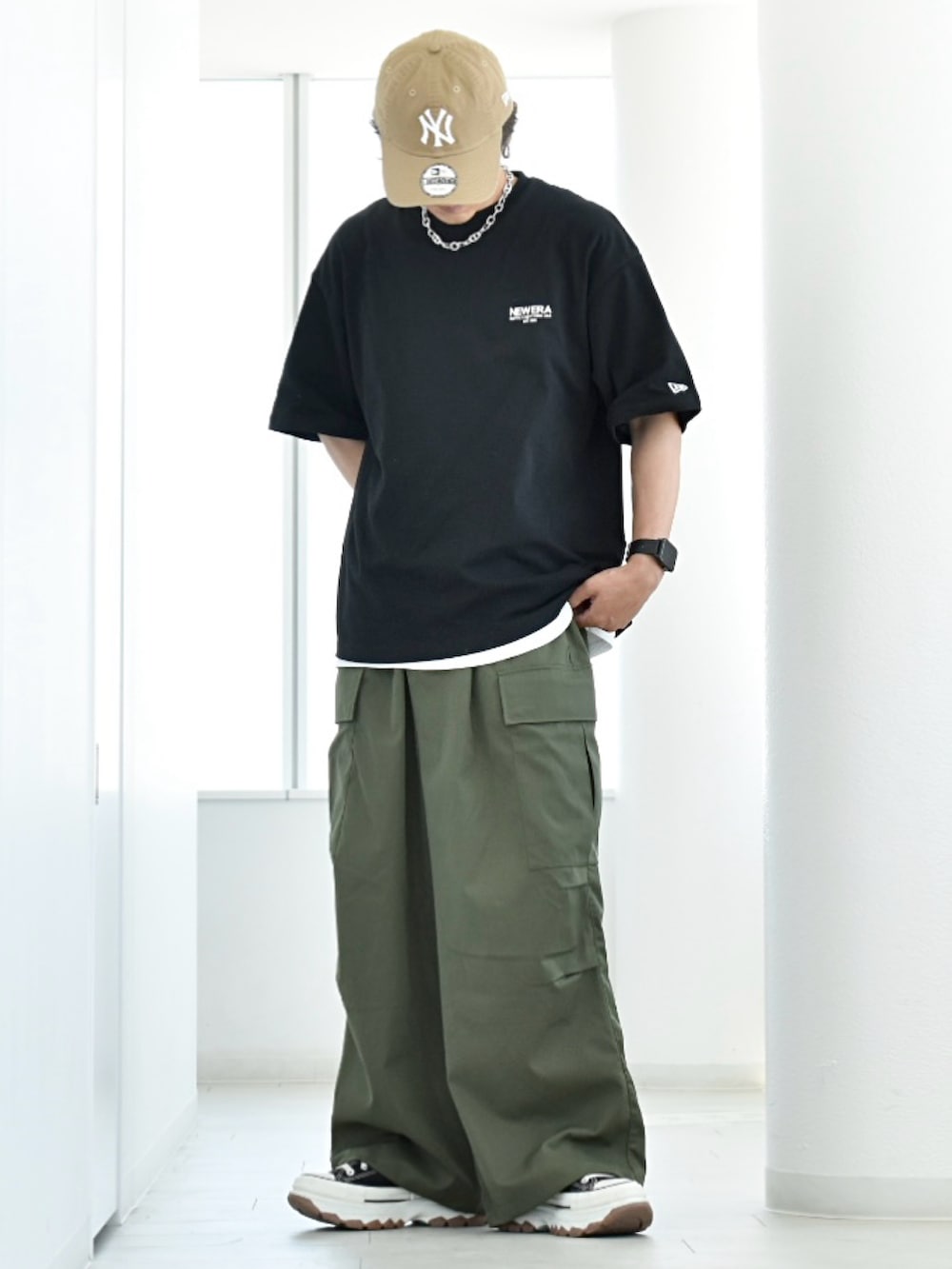 ブラック系のTシャツ/カットソー、グリーン系のカーゴパンツ、ブラック系のスニーカーを着用したメンズの夏コーディネートの2枚目の写真