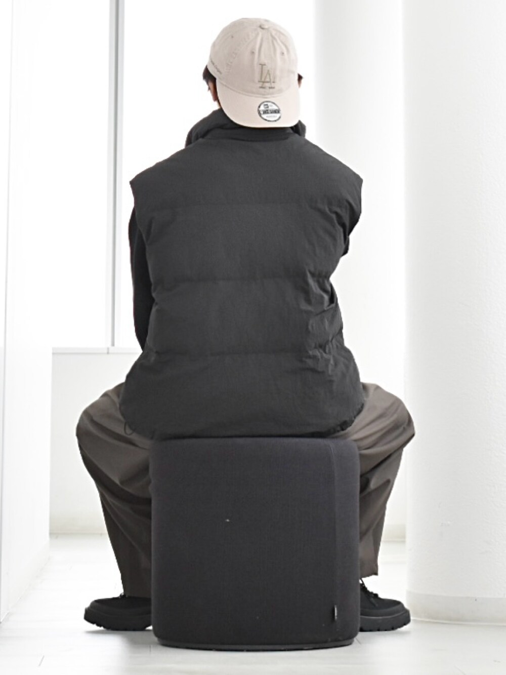 ブラック系のダウンベスト、その他のスラックス、ブラック系のブーツを着用したメンズの秋コーディネートの4枚目の写真