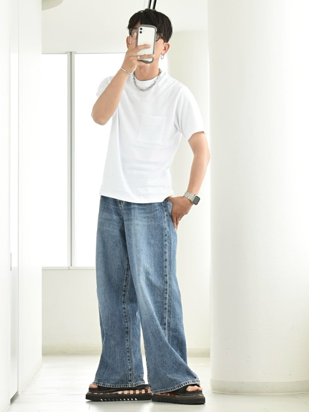 ホワイト系のTシャツ/カットソー、ブラック系のサンダル、ブルー系のデニムパンツを着用したメンズの夏コーディネートの3枚目の写真