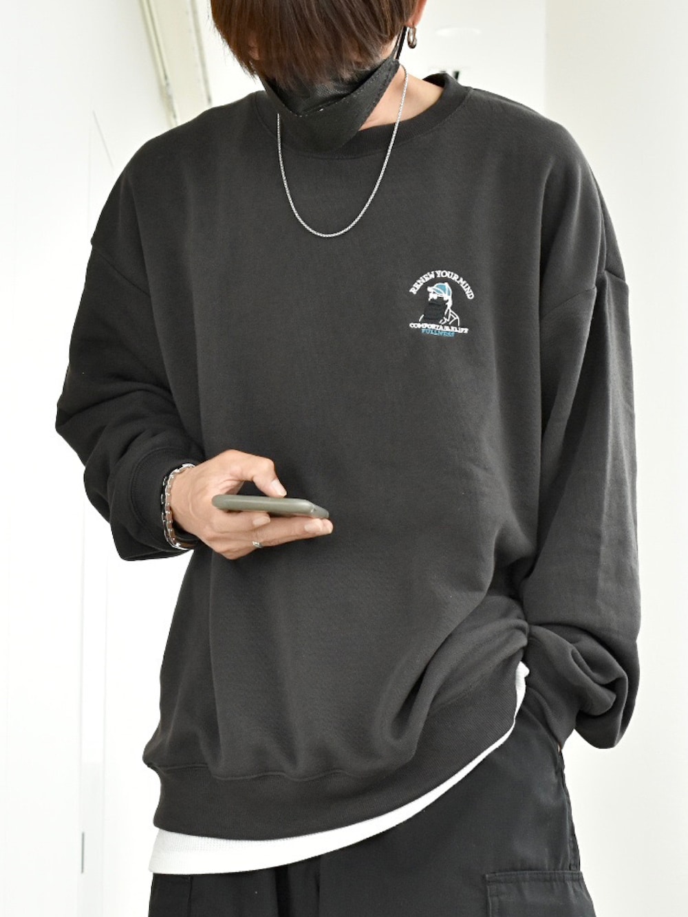 グレー系のスウェット、ホワイト系のタンクトップ、ブラック系のカーゴパンツを着用したメンズの秋コーディネートの2枚目の写真