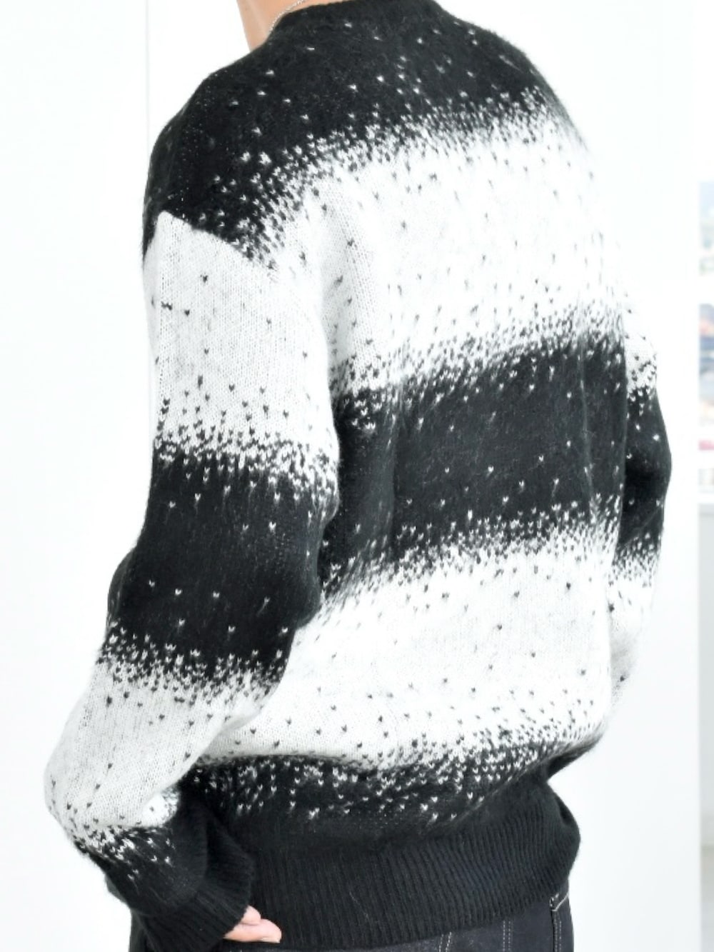 ブラック系のニット/セーター、ブルー系のデニムパンツ、ブラック系のローファーを着用したメンズの秋コーディネートの4枚目の写真