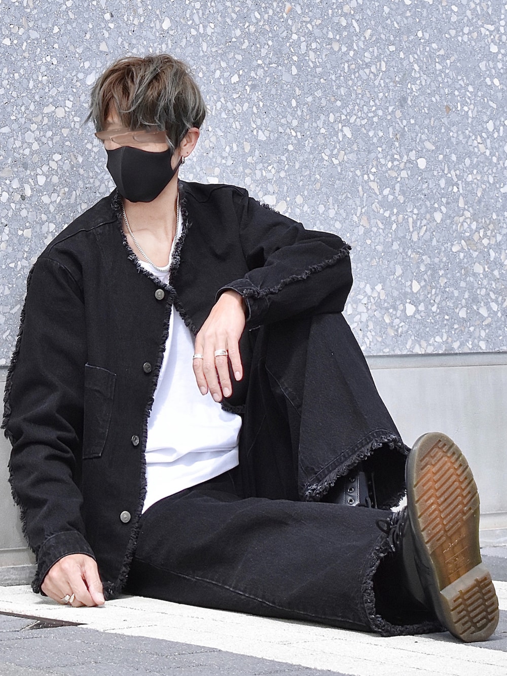 ブラック系のデニムジャケット、ブラック系のデニムパンツ、ブラック系のブーツを着用したメンズの春コーディネートの2枚目の写真
