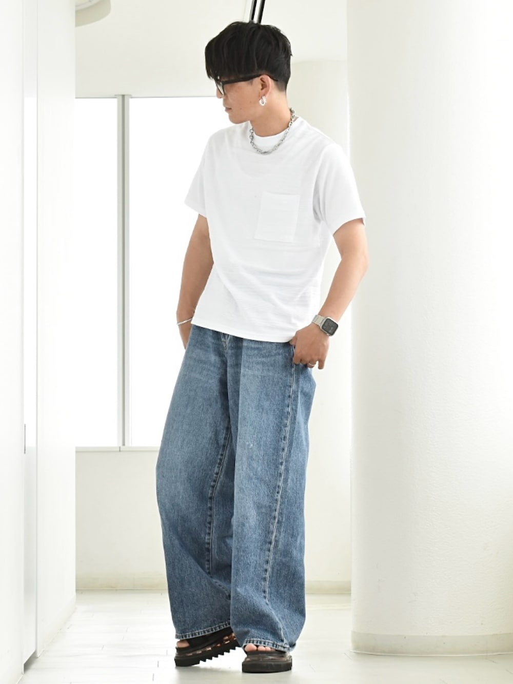 ホワイト系のTシャツ/カットソー、ブラック系のサンダル、ブルー系のデニムパンツを着用したメンズの夏コーディネートの2枚目の写真
