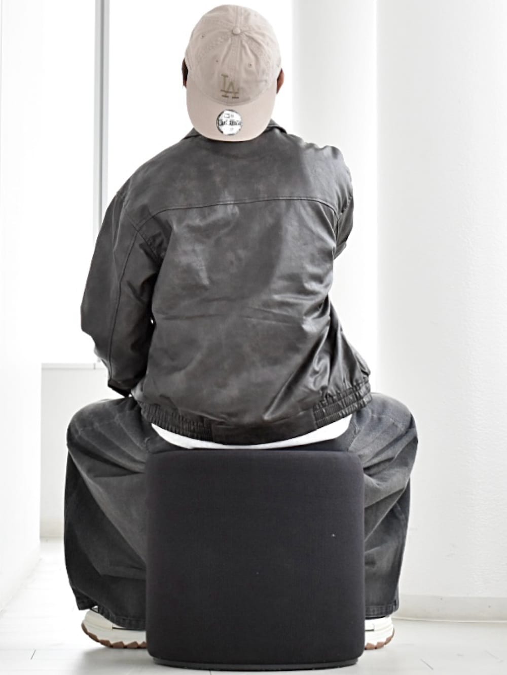 ブラック系のブルゾン、グレー系のスウェット、ブラック系のデニムパンツを着用したメンズの秋コーディネートの3枚目の写真