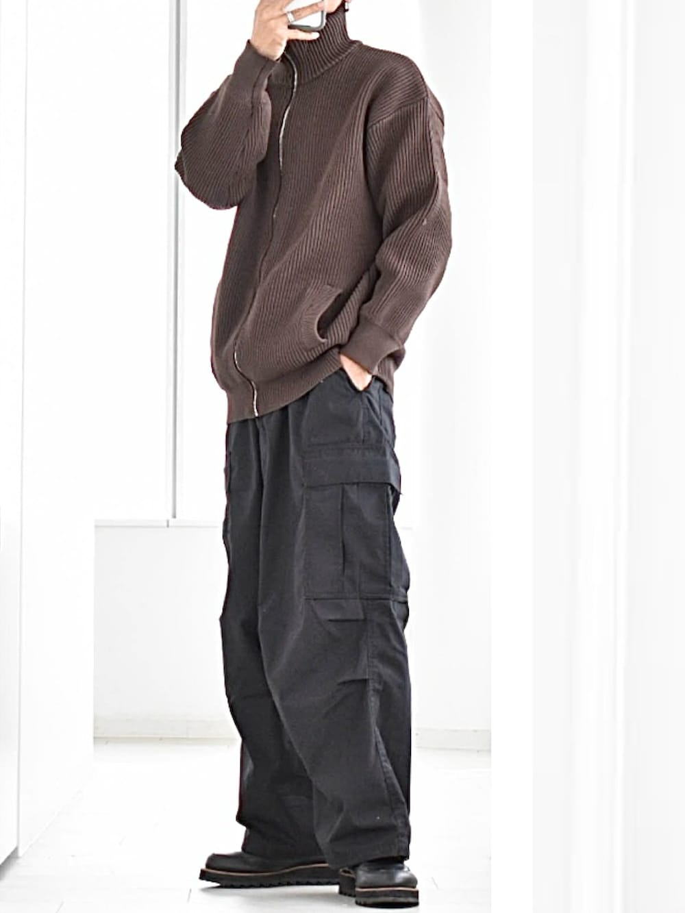 ブラウン系のニット/セーター、ホワイト系のTシャツ/カットソー、ブラック系のカーゴパンツを着用したメンズの春コーディネートの2枚目の写真