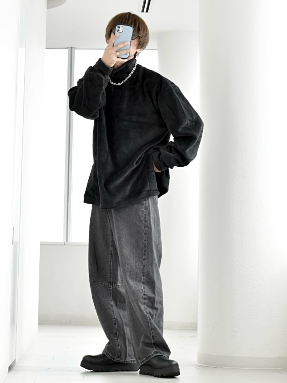 ブラック系のニット/セーター、ブラック系のデニムパンツ、ブラック系のブーツを着用したメンズの秋コーディネートの2枚目の写真