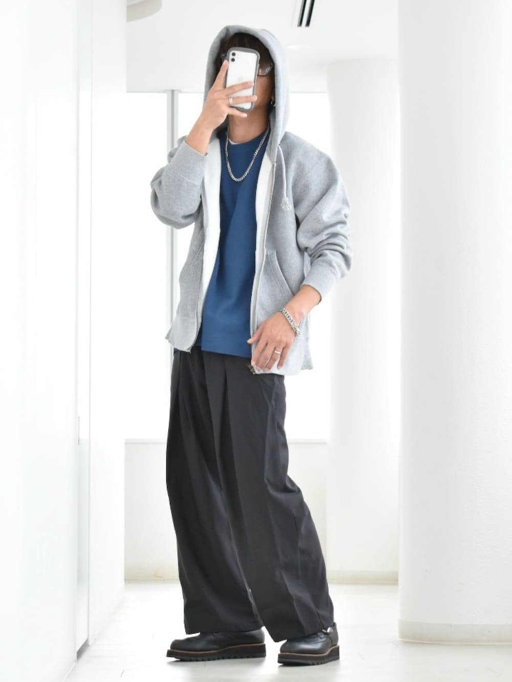 ブラック系のスラックス、ブルー系のTシャツ/カットソー、グレー系のスウェットを着用したメンズの冬コーディネートの2枚目の写真